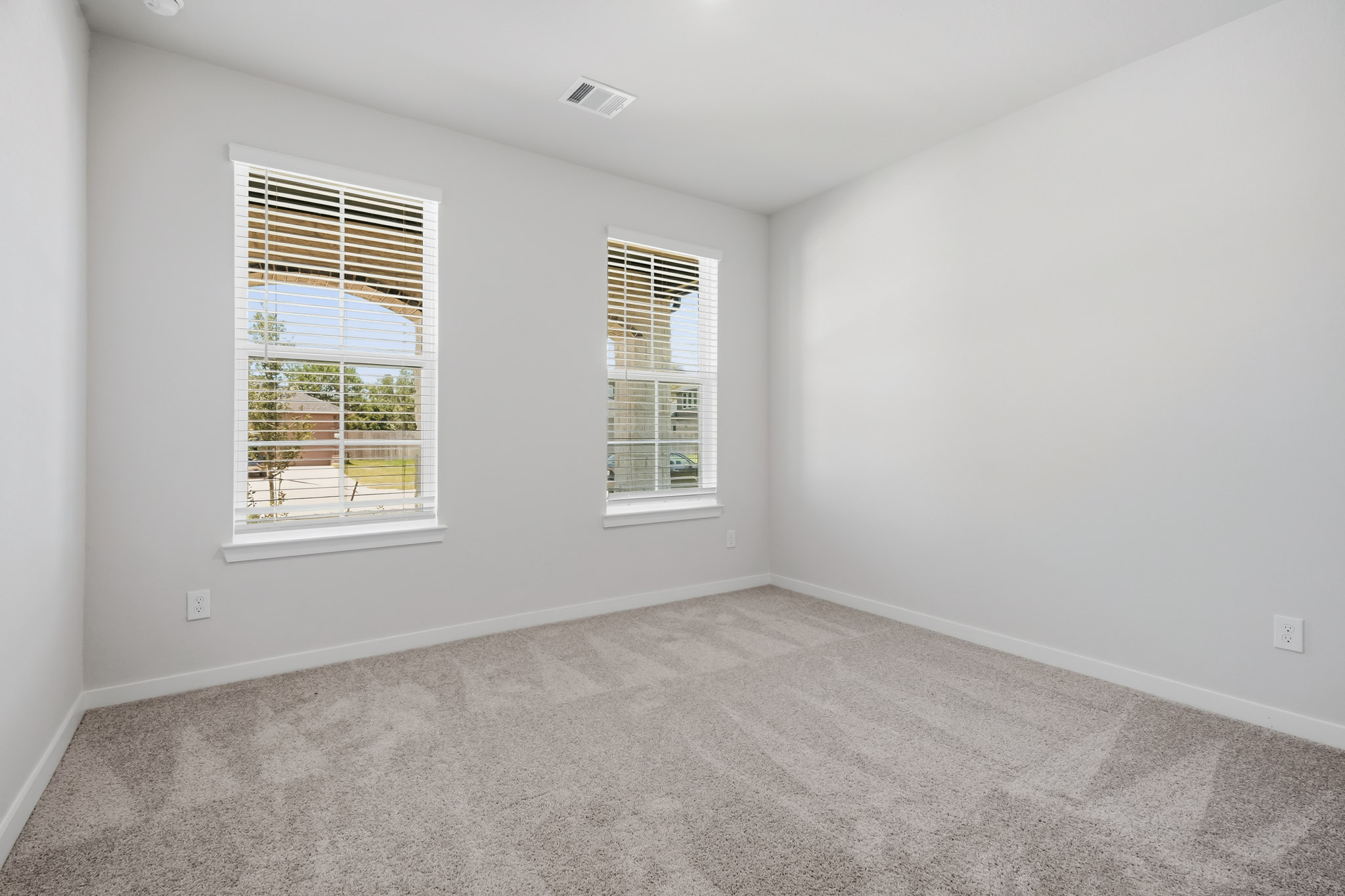 A room with windows and a carpet.