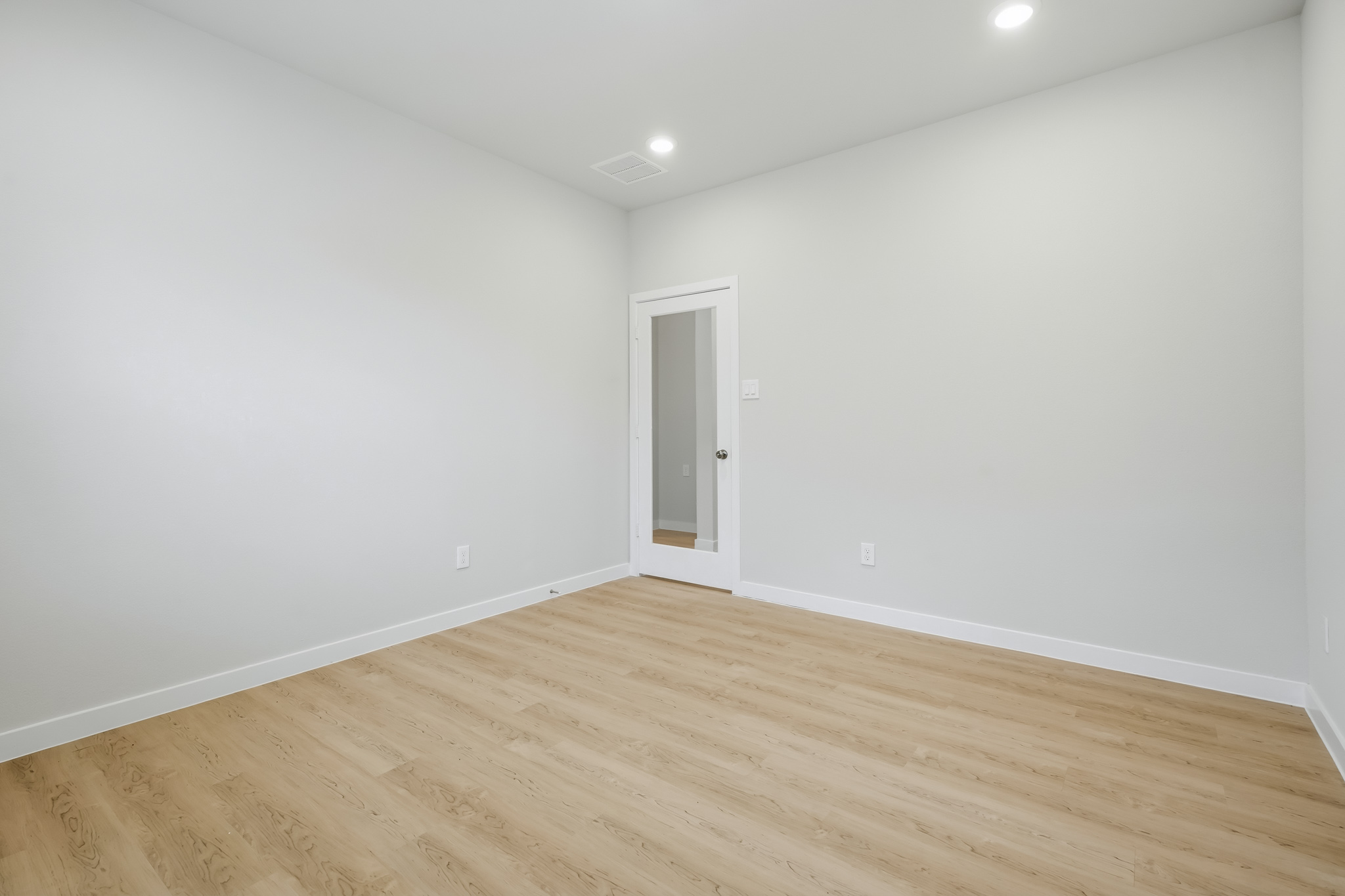 A room with a wood floor and a white door.