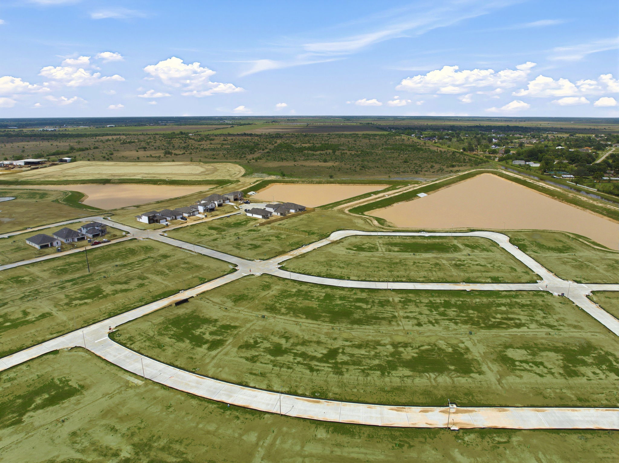 A large field with a few buildings.