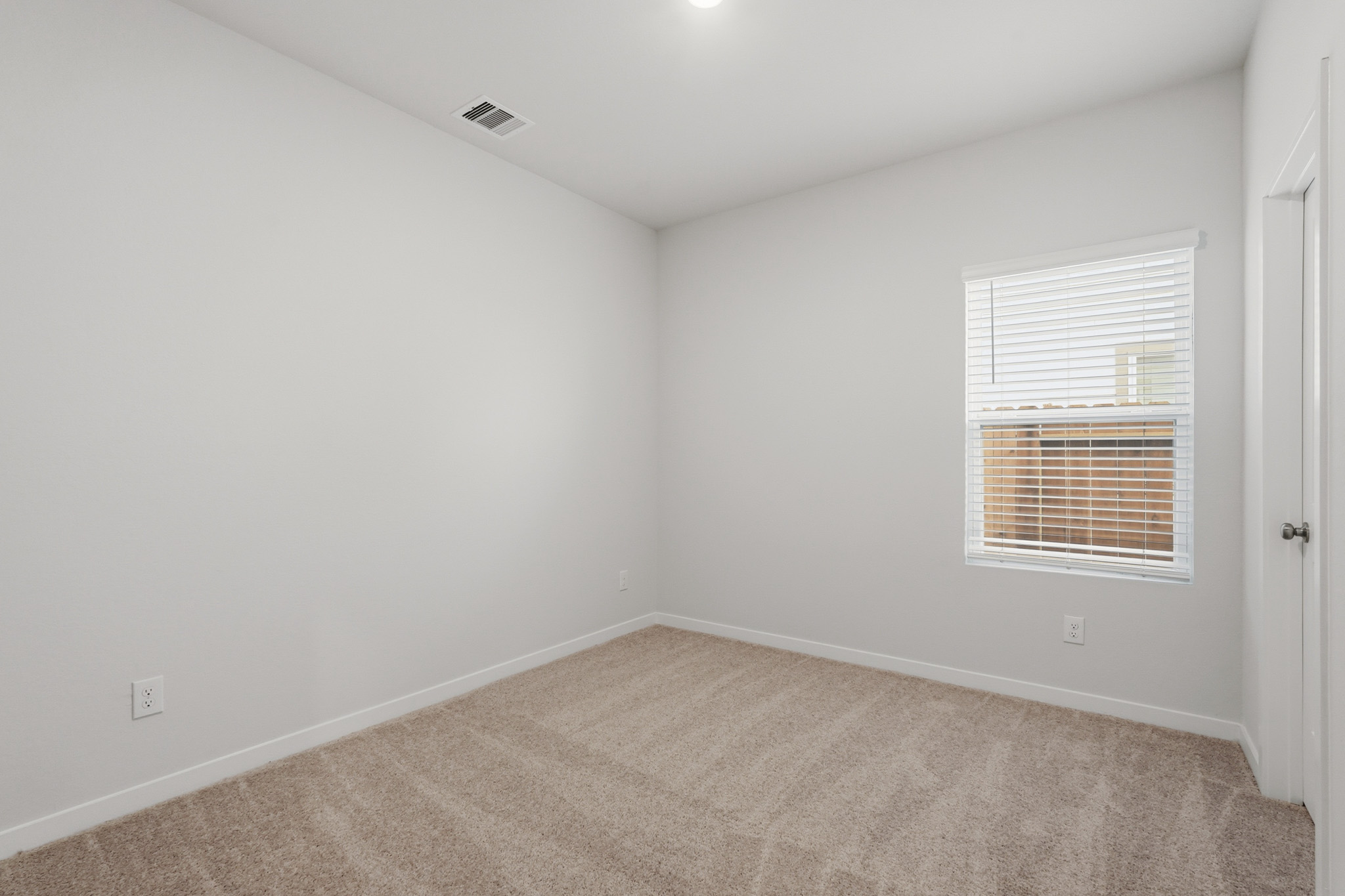 A room with a carpet and a window.
