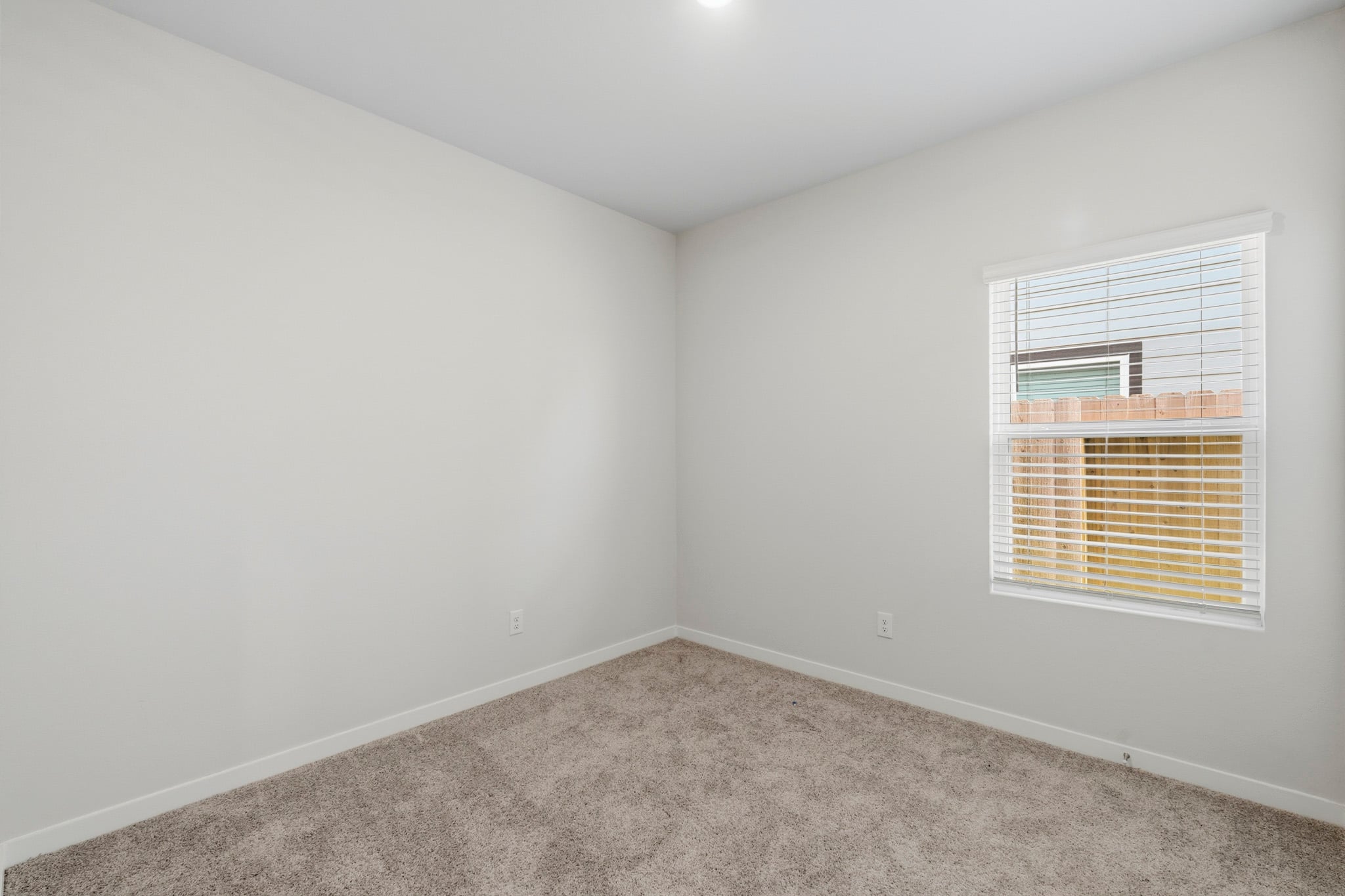 A room with a window and carpet.