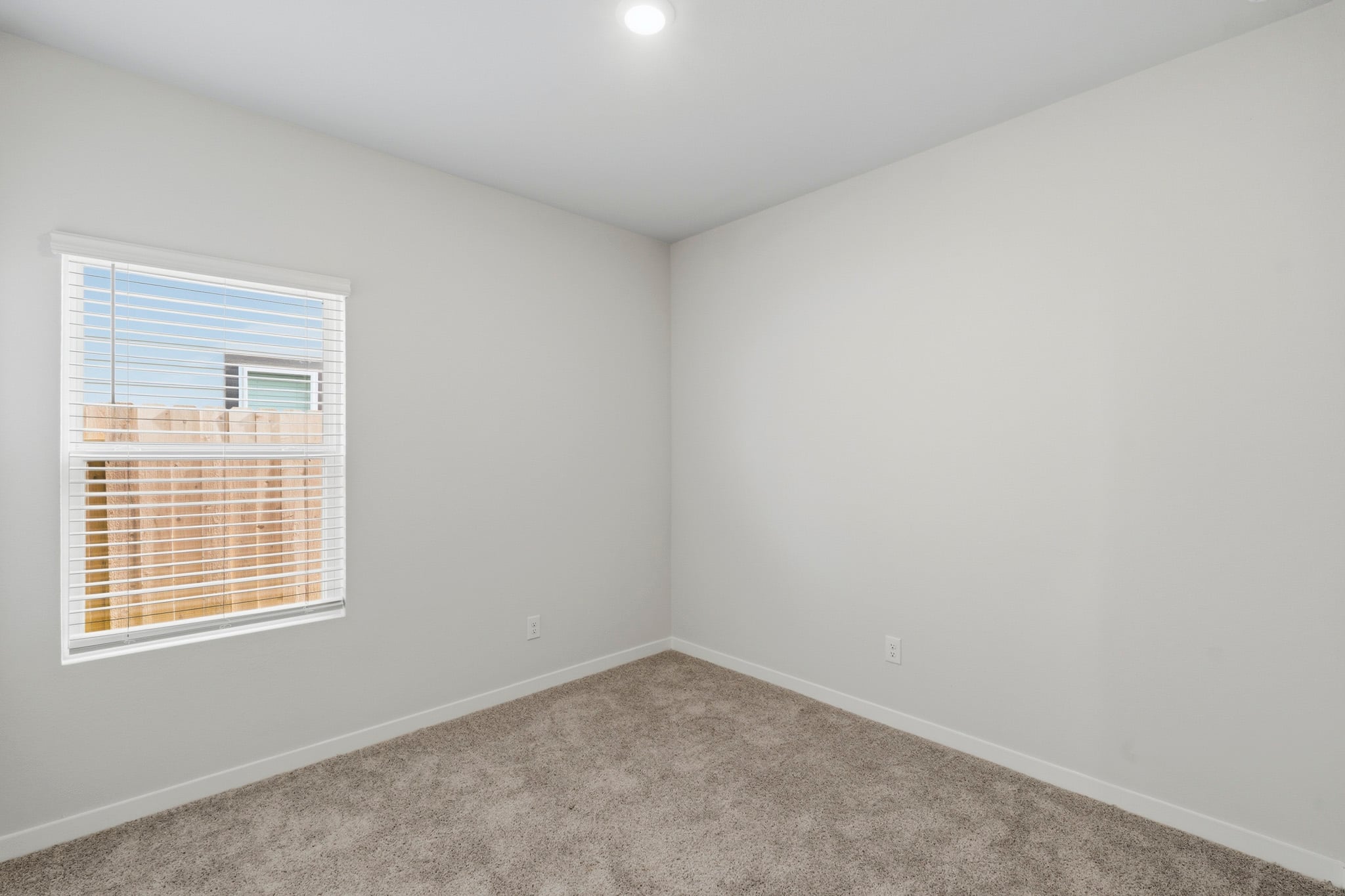 A room with a window and carpet.