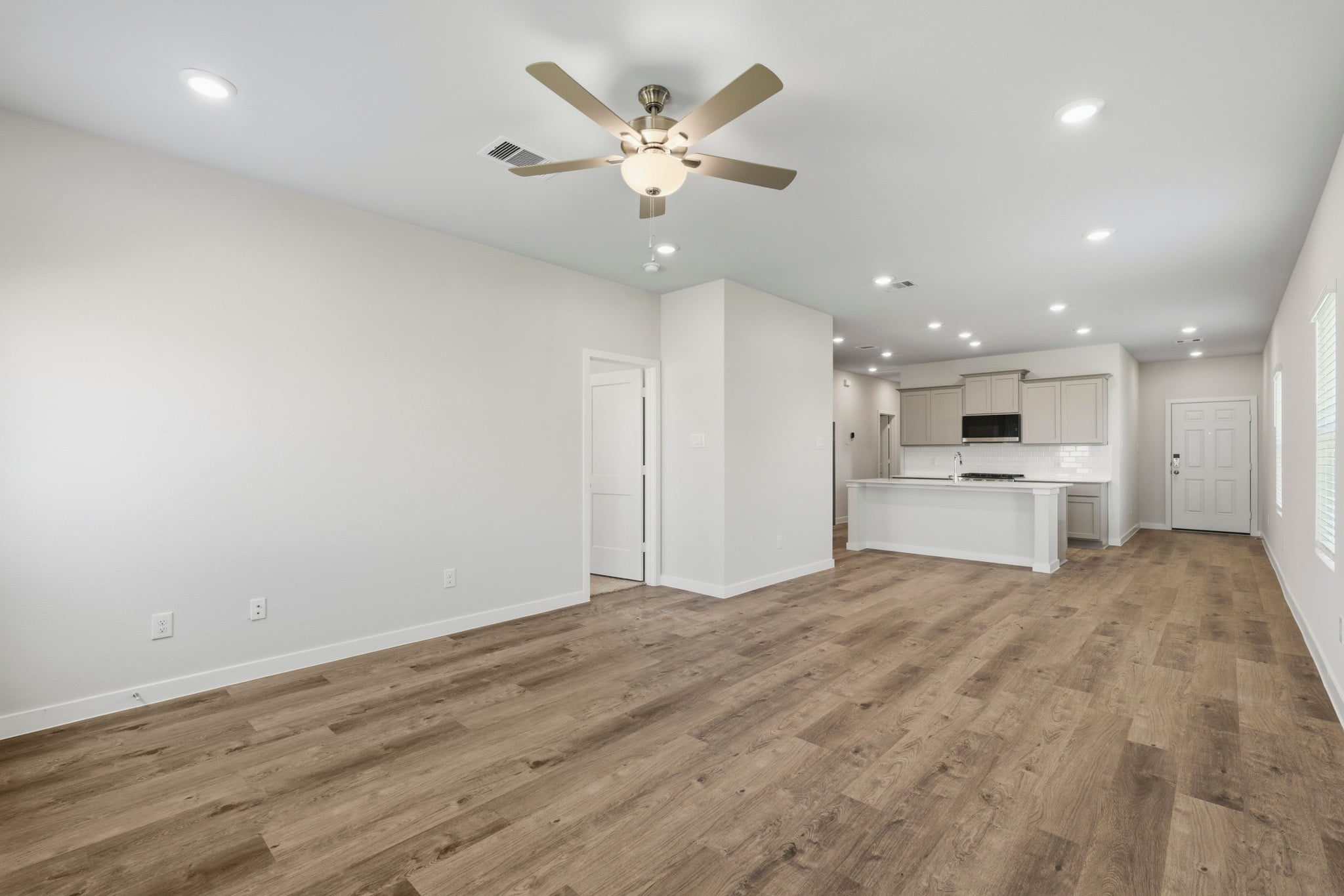 A room with a wood floor and a ceiling fan.