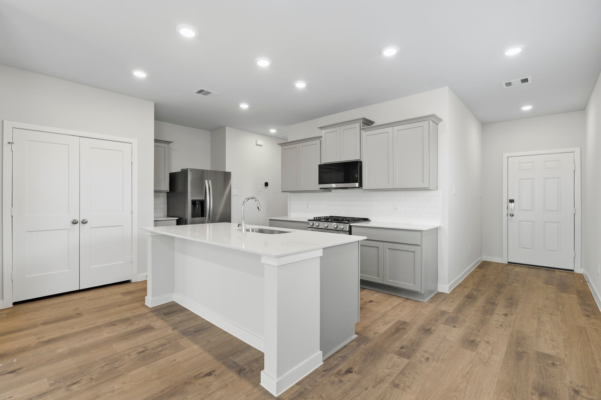 A kitchen with white cabinets.