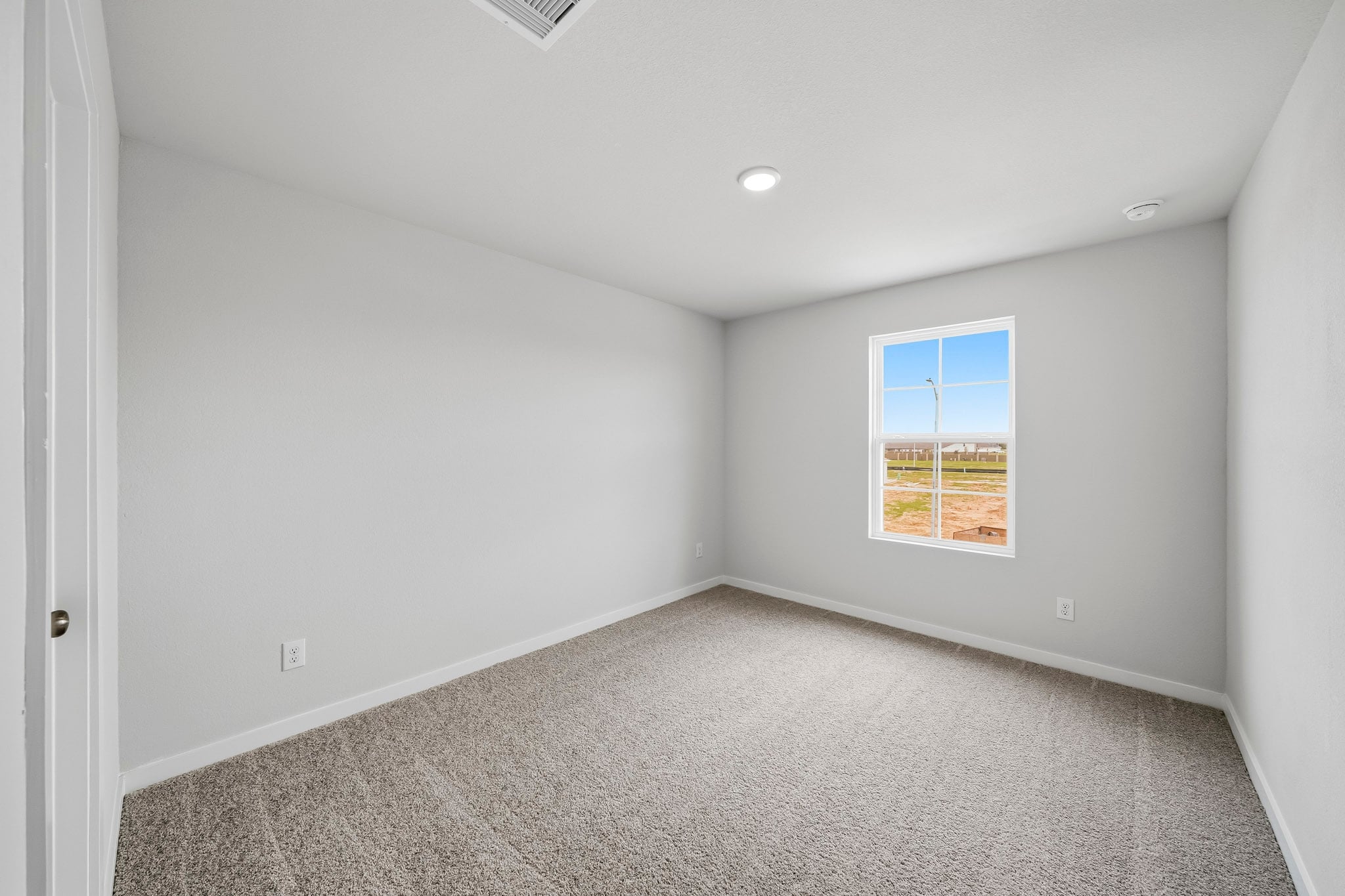 A room with a carpet and a window.