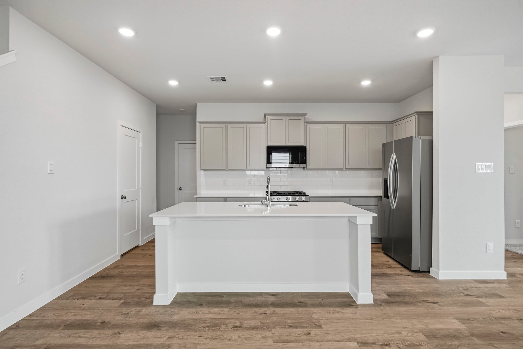 A kitchen with white cabinets.