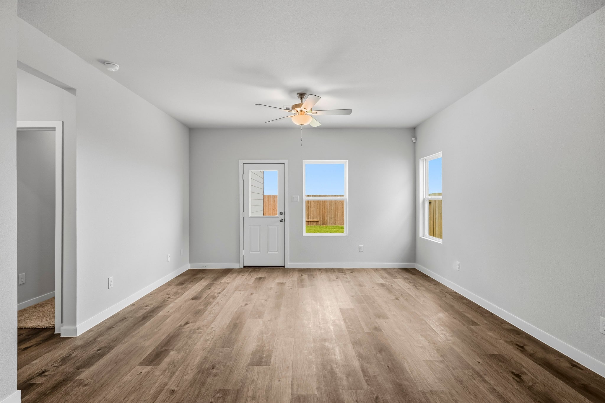 A room with a wood floor and a ceiling fan.