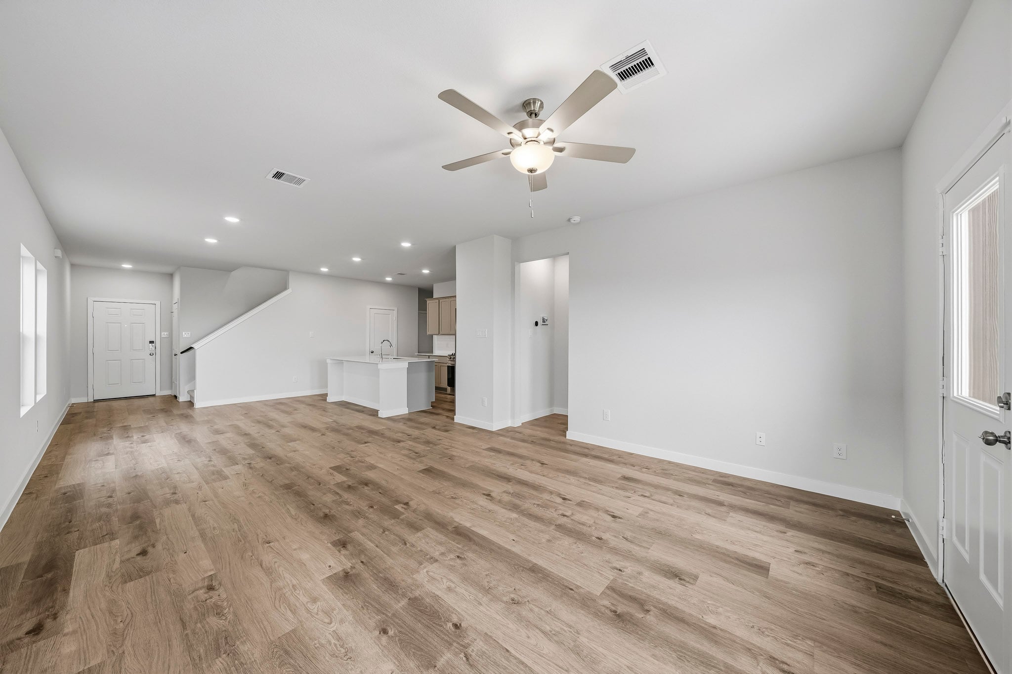 A room with a wood floor and a ceiling fan.