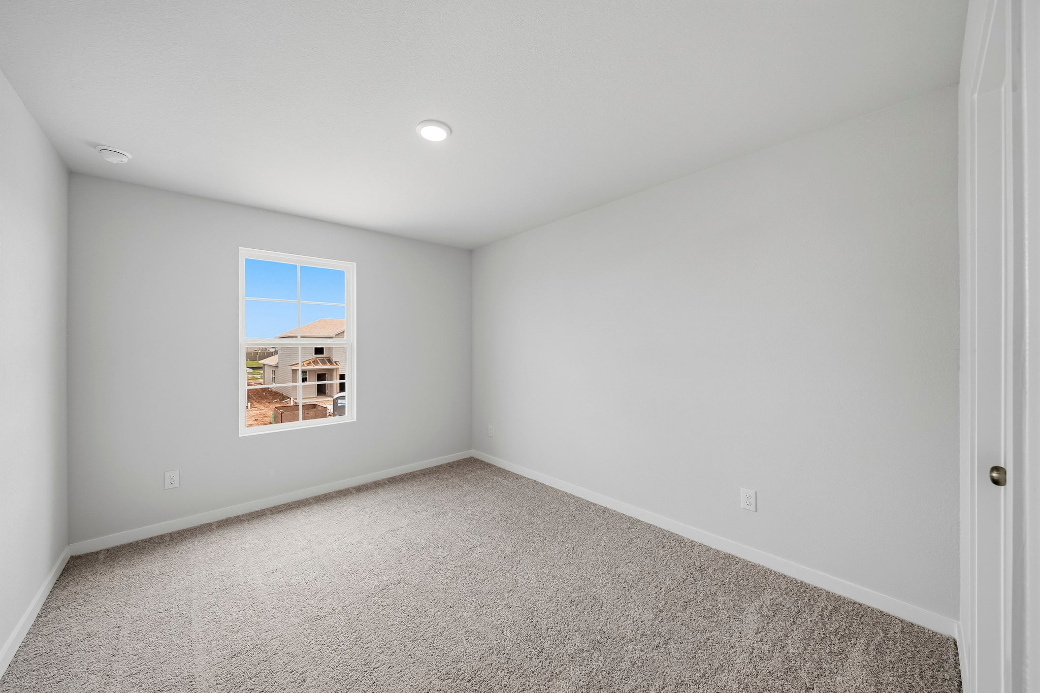 A room with a window and carpet.