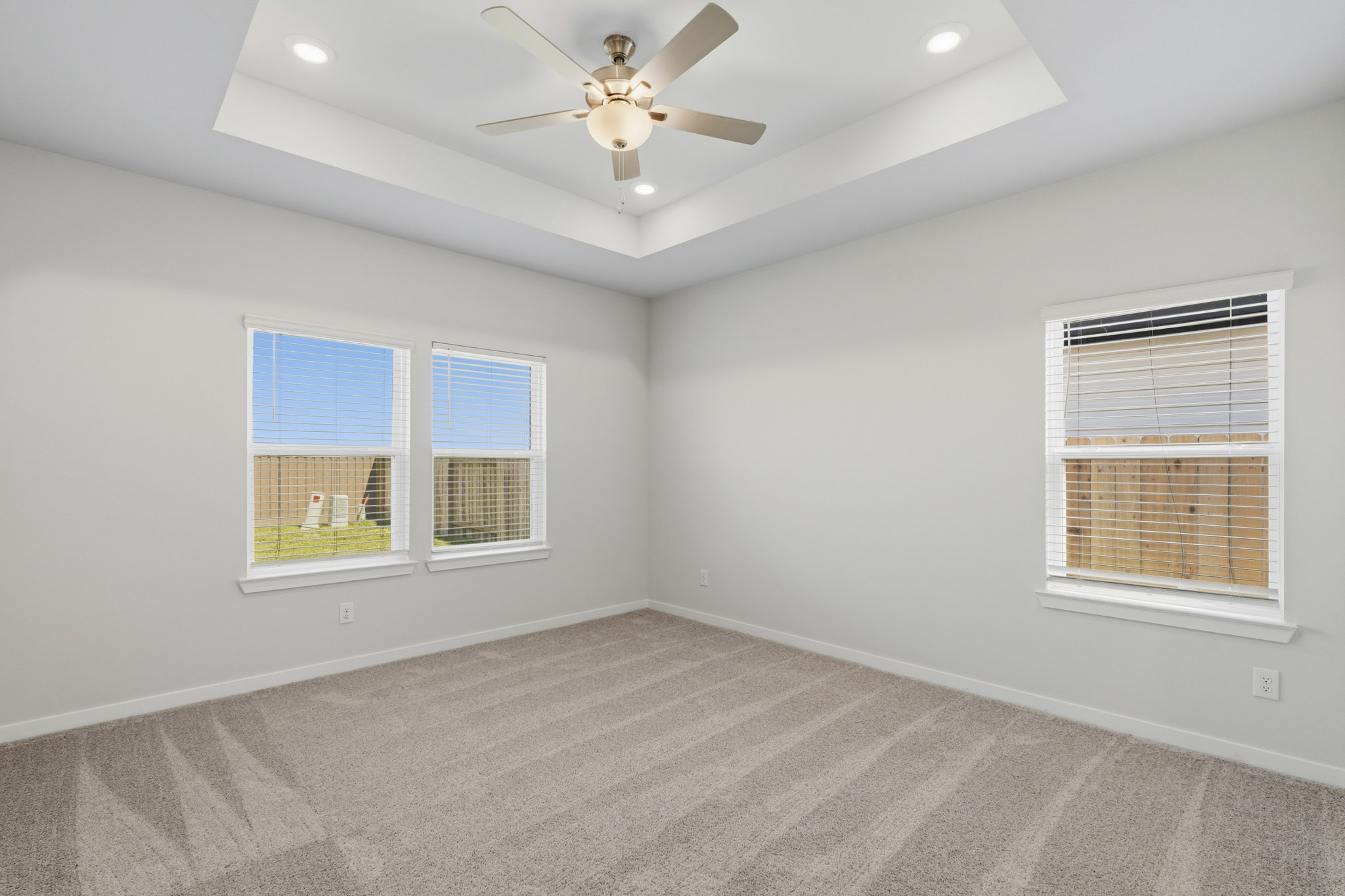 A room with a ceiling fan and a window.