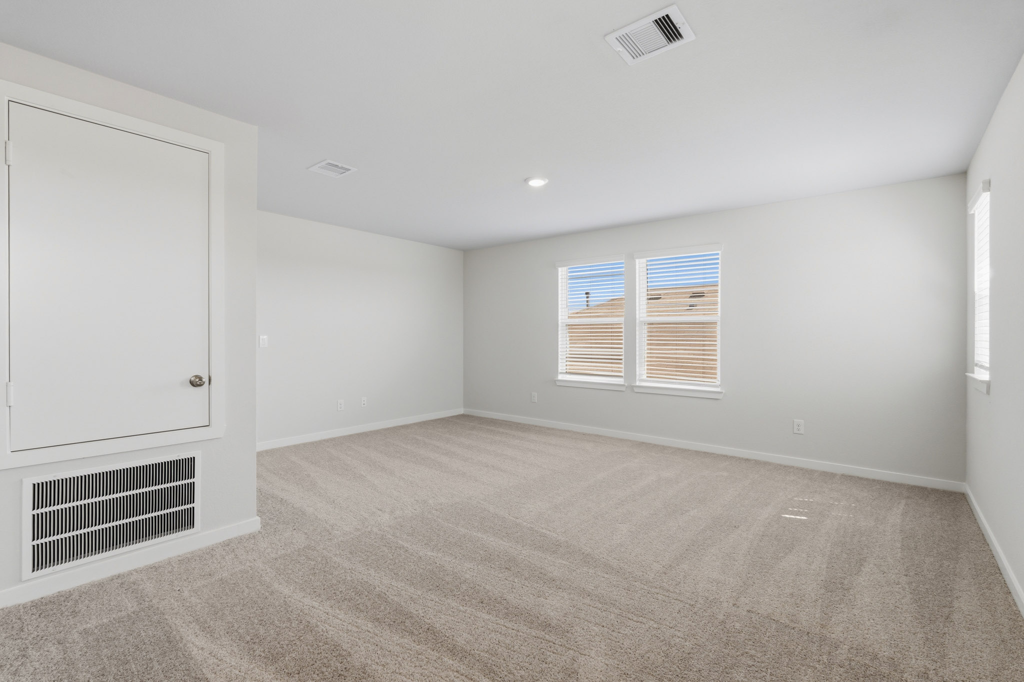 A room with a carpet and windows.