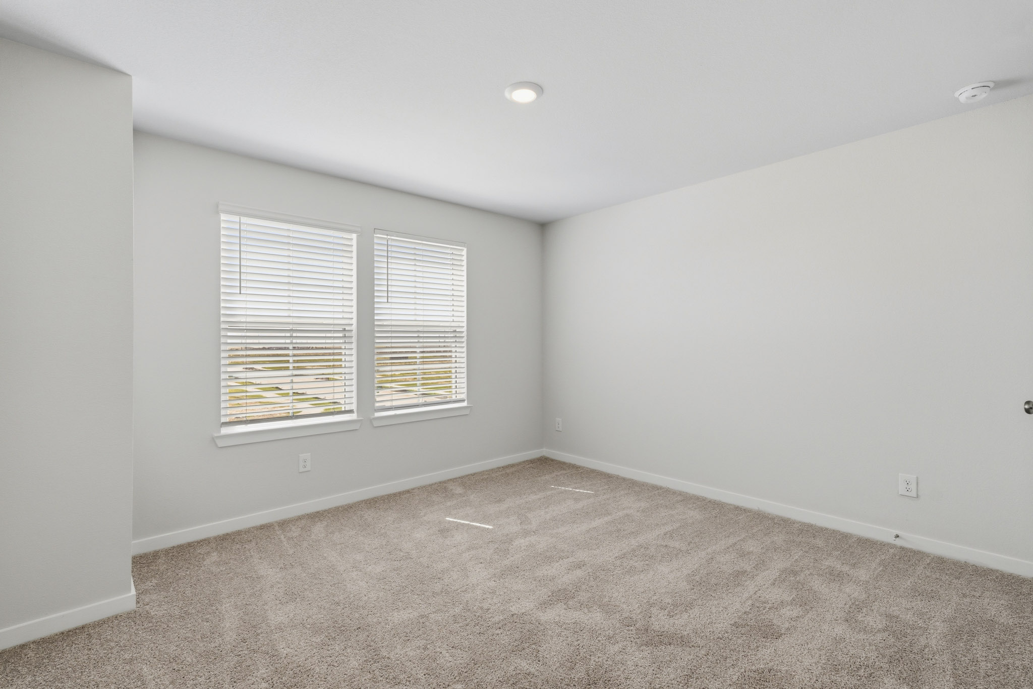 A room with a carpet and a window.