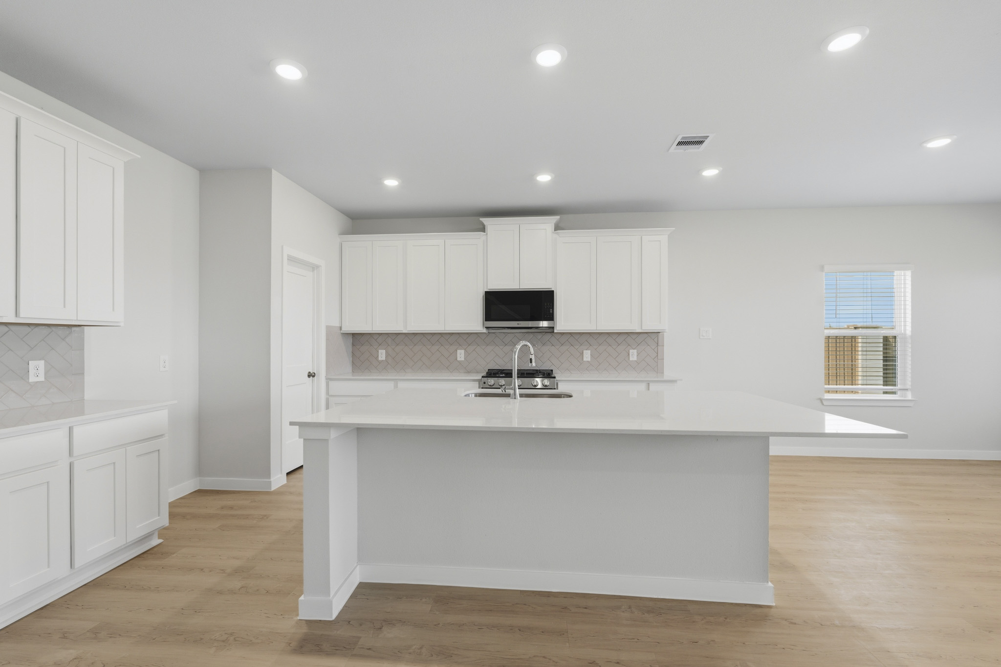 A kitchen with white cabinets.