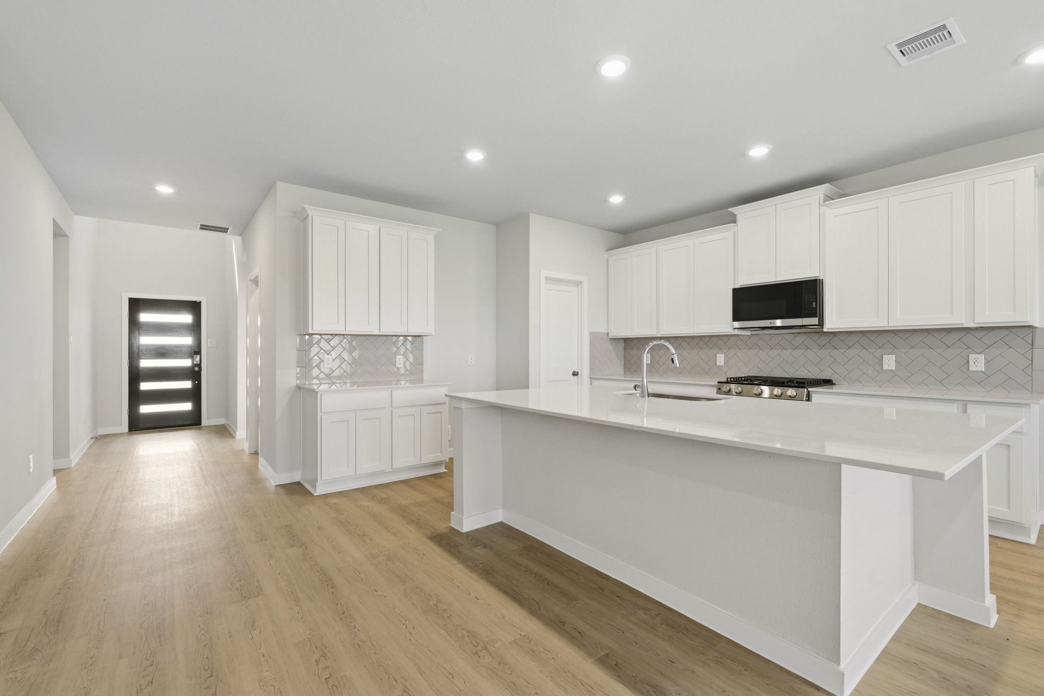 A kitchen with white cabinets.