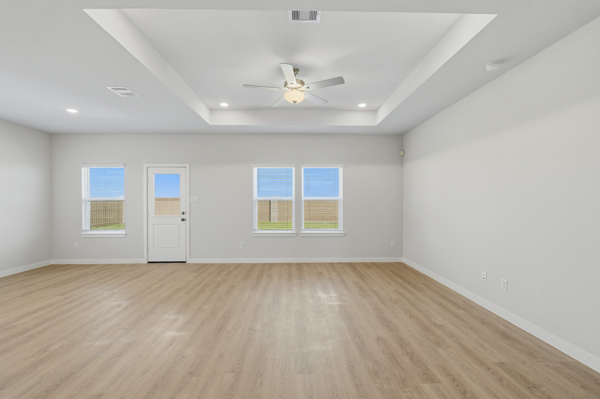 A room with a wood floor and a ceiling fan.