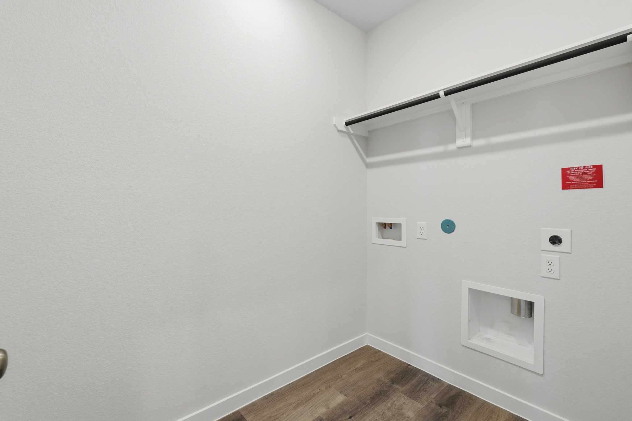 A white wall with a wood floor and a wood floor.