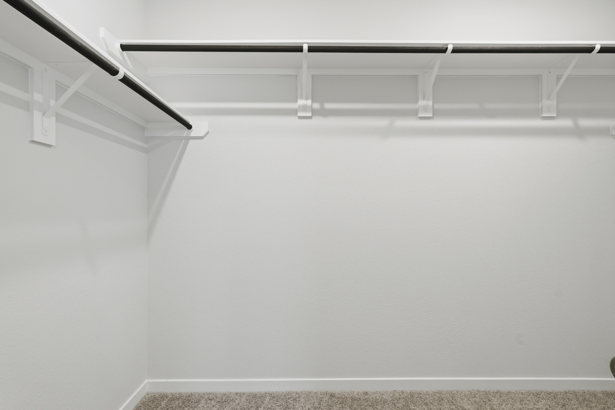 A white wall with a metal bar.