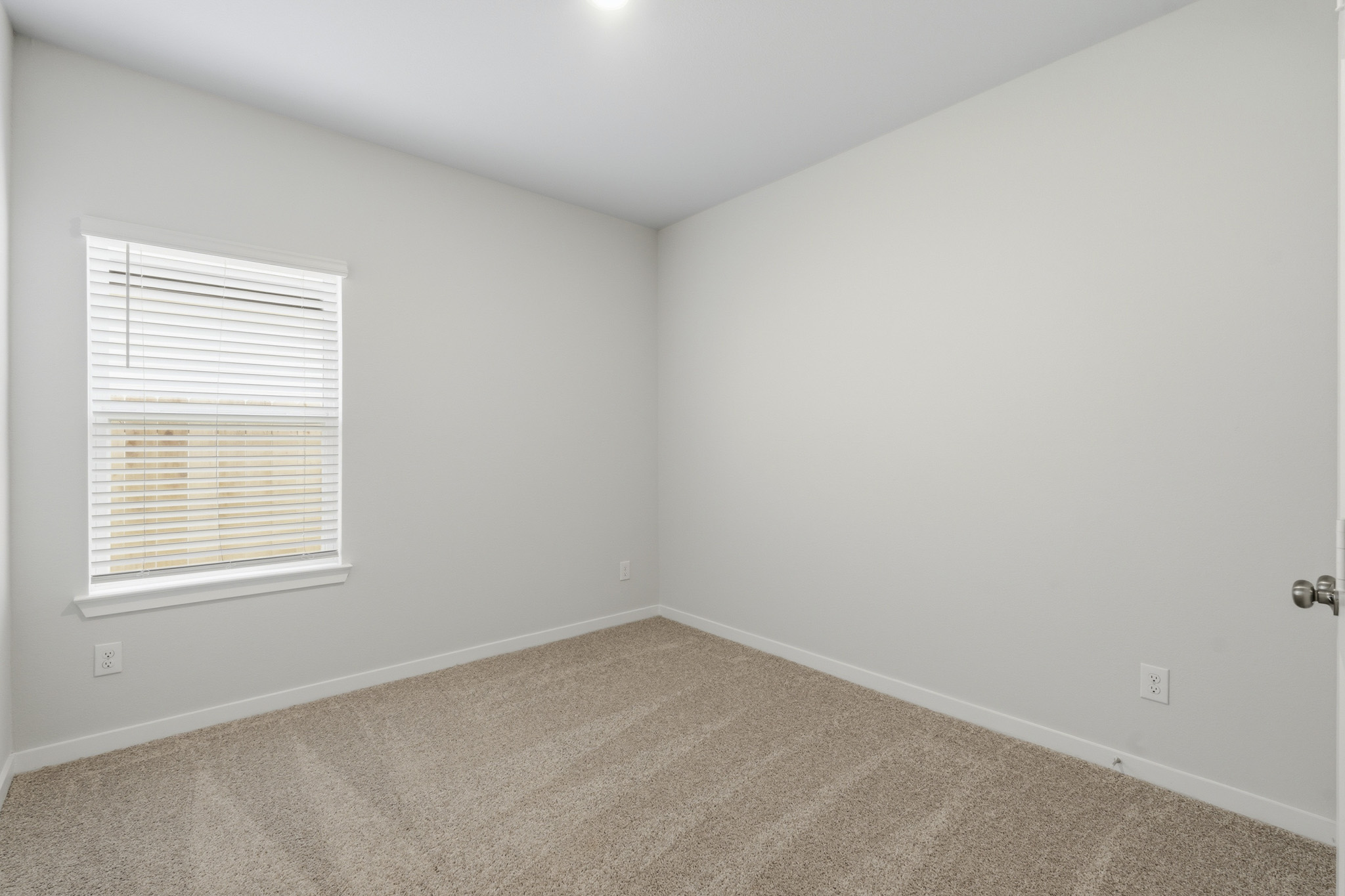 A room with a window and a carpet.
