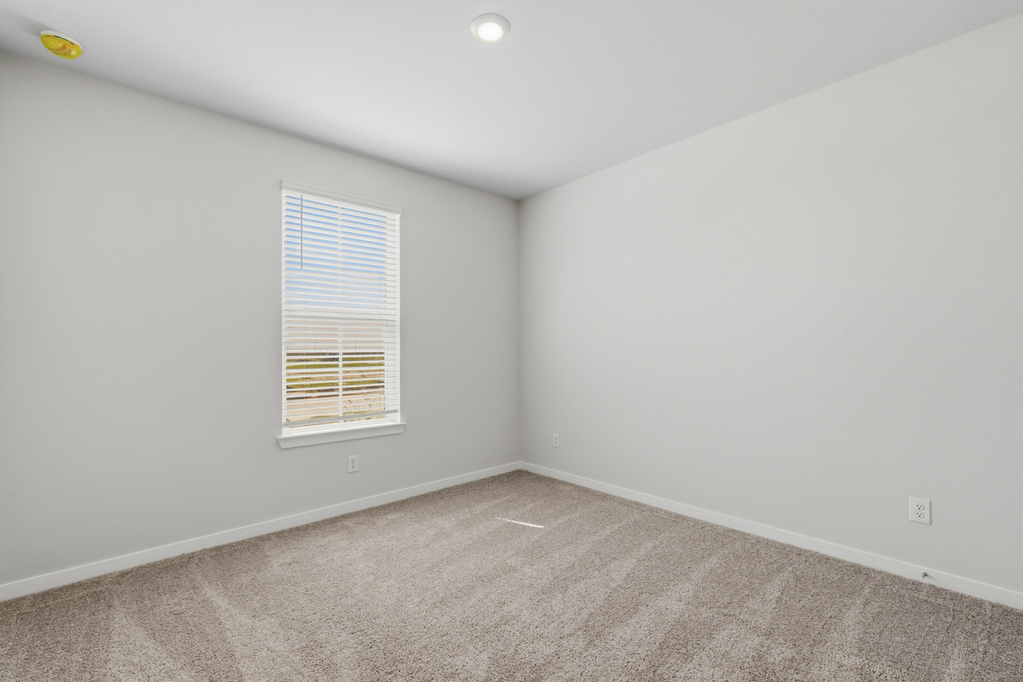 A room with a window and carpet.