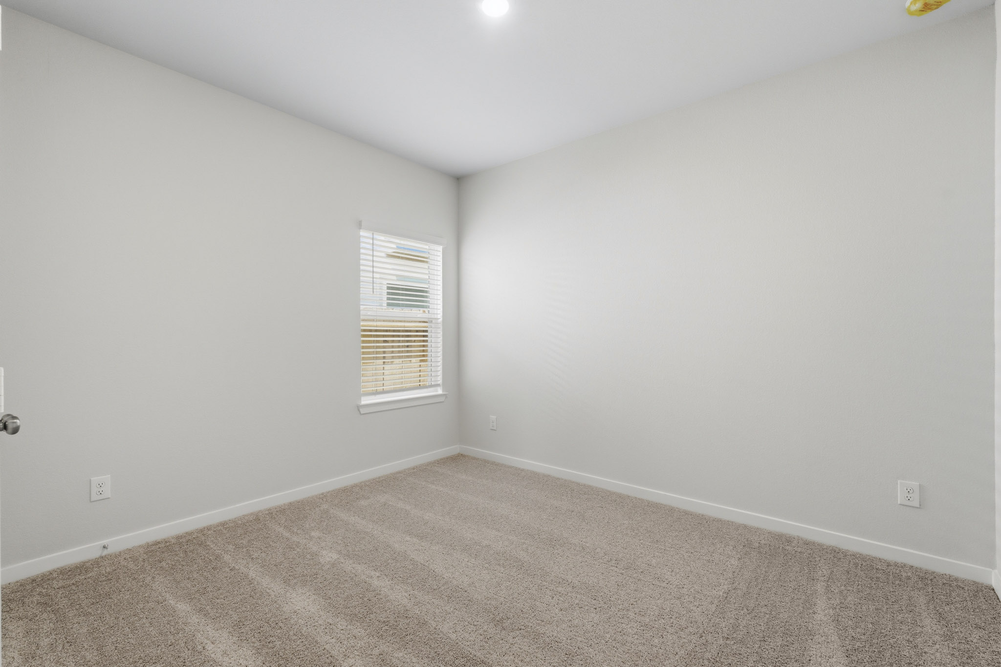 A room with a window and carpet.