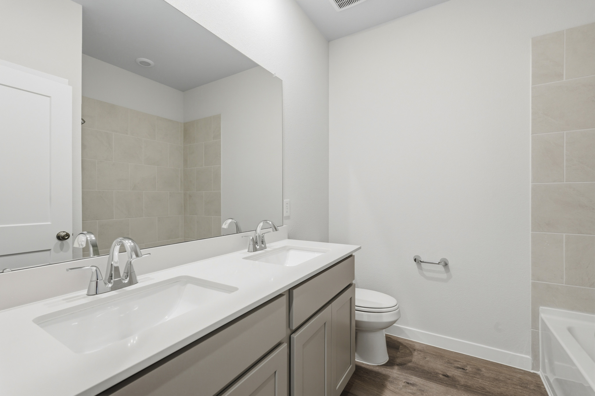 A bathroom with a large mirror.