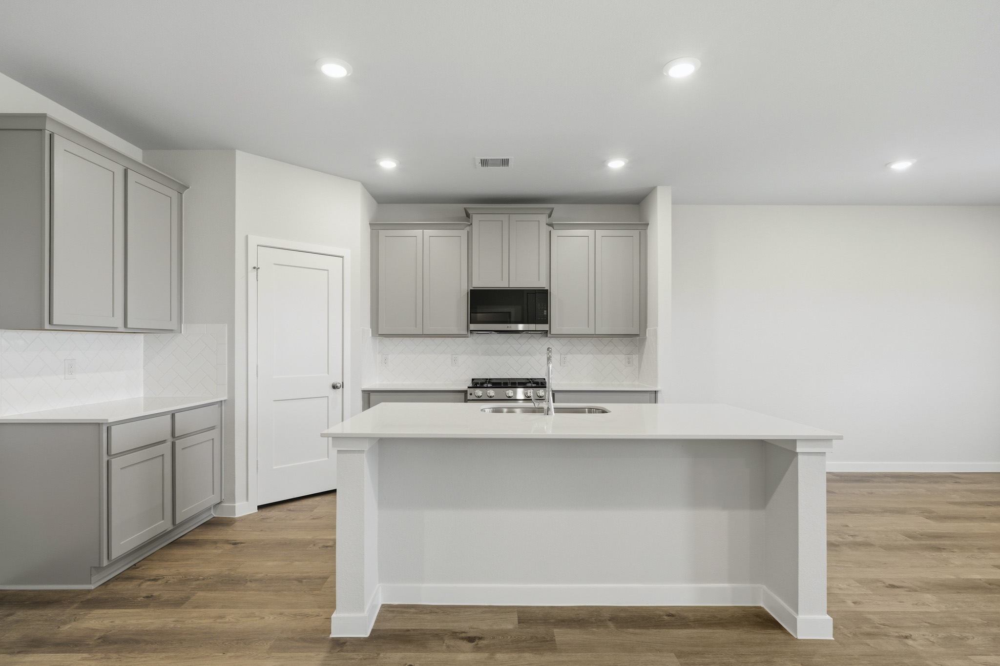 A kitchen with white cabinets.