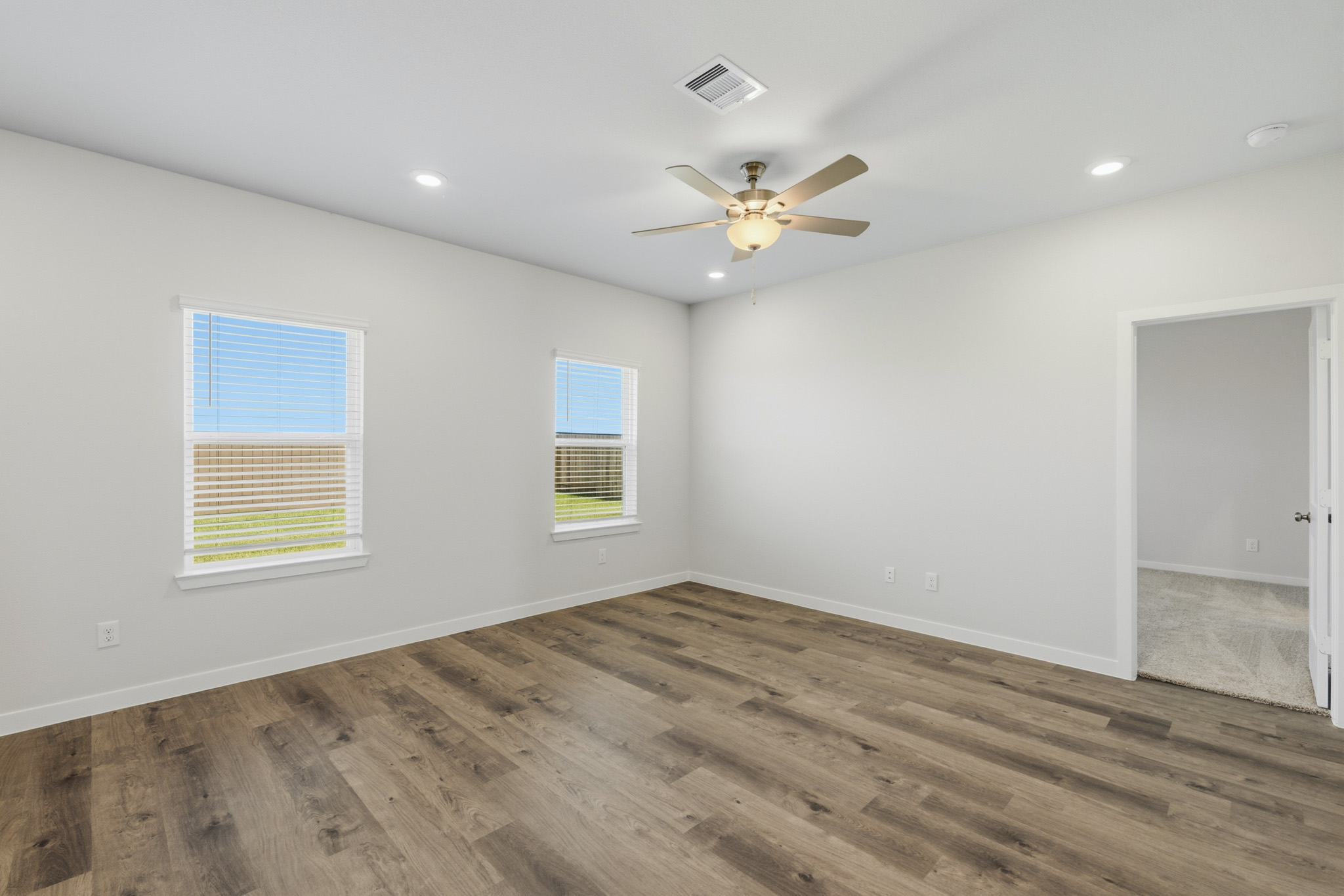 A room with a wood floor and a ceiling fan.