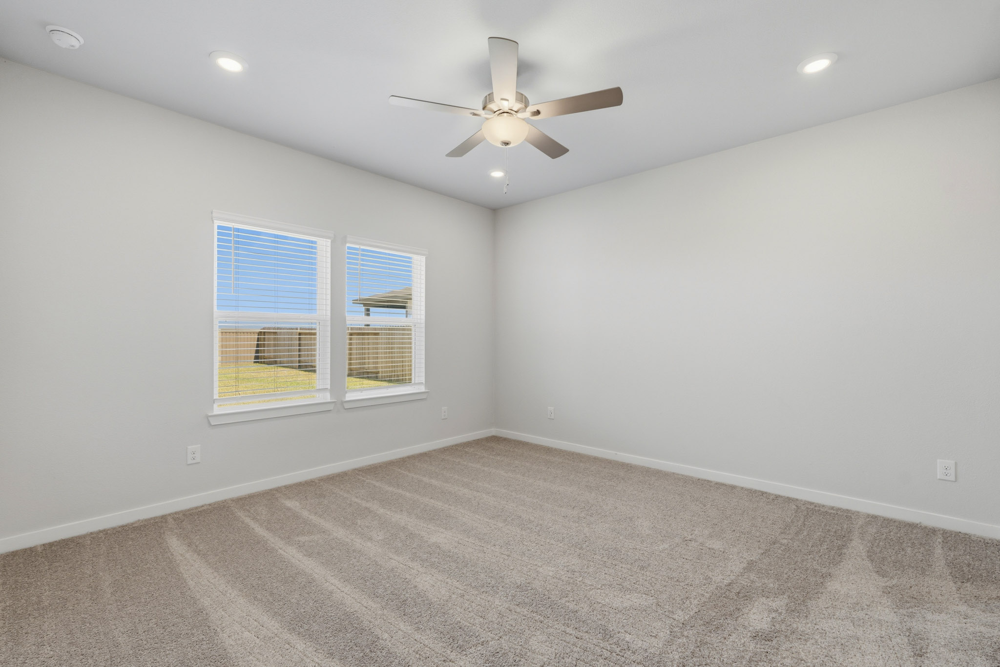 A room with a ceiling fan and a window.