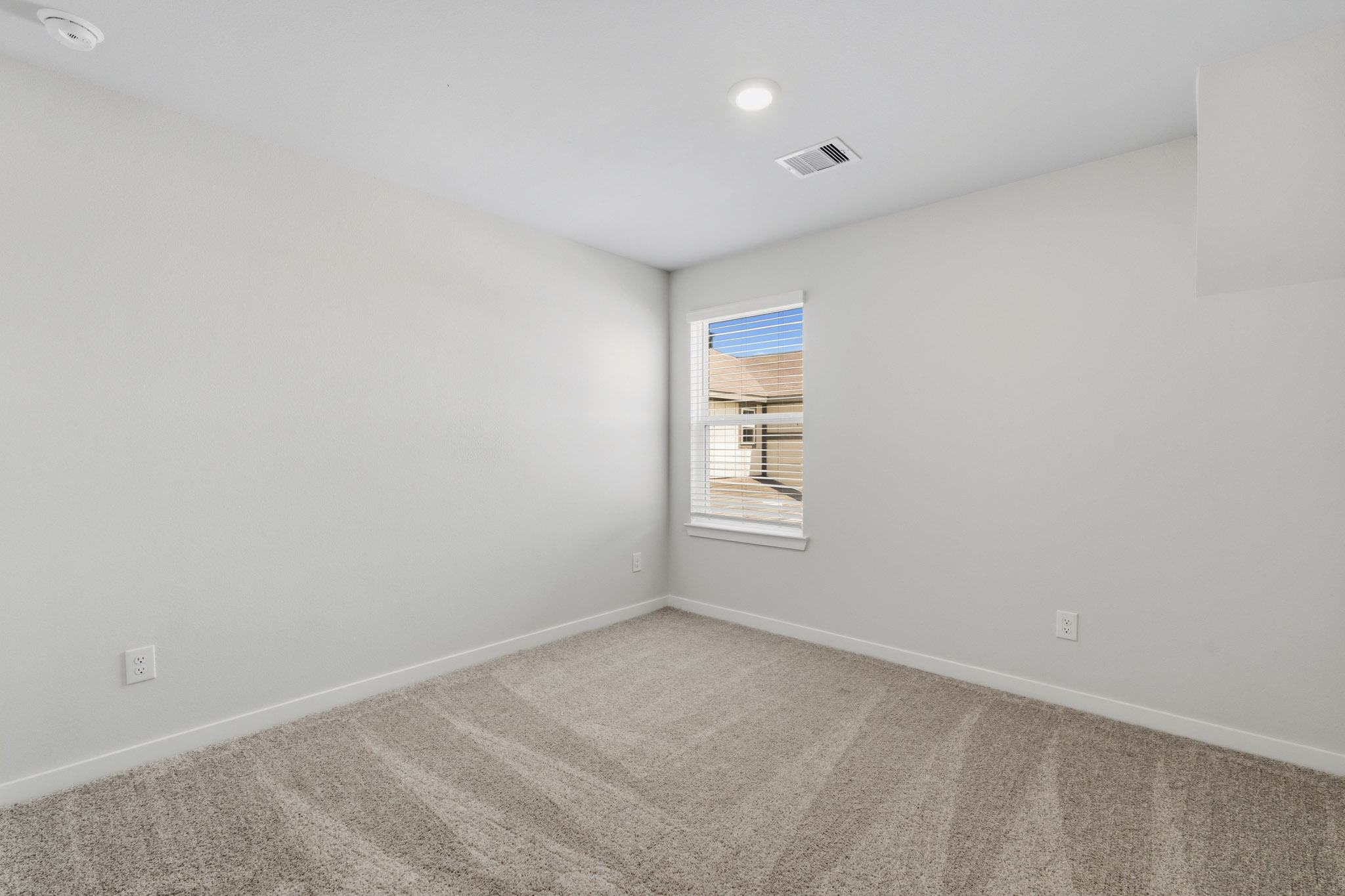 A room with a window and carpet.