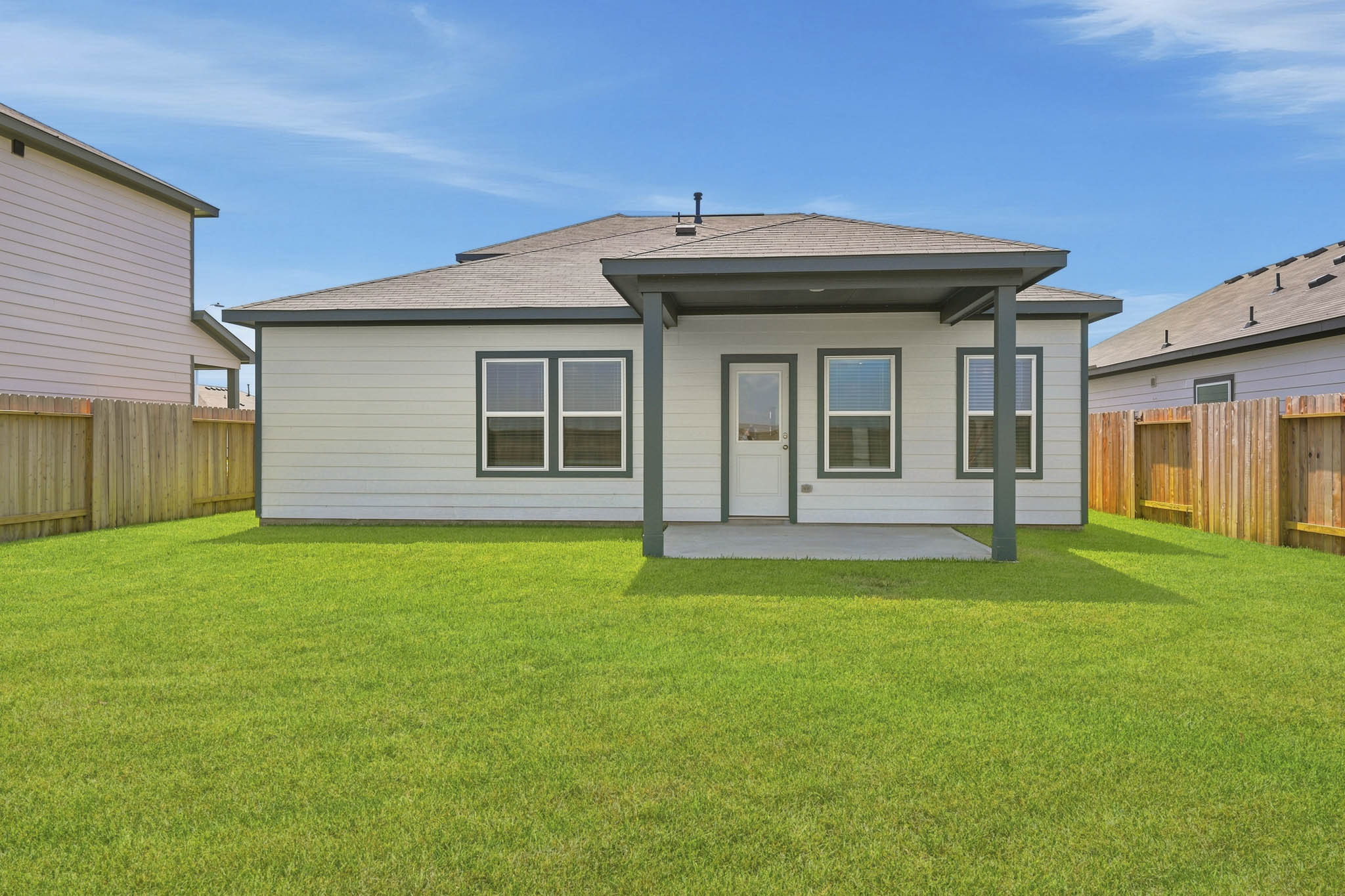 A house with a fence and grass.