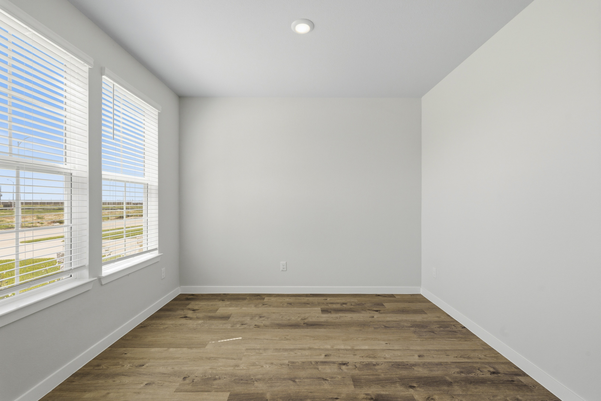 A room with windows and wood floor.