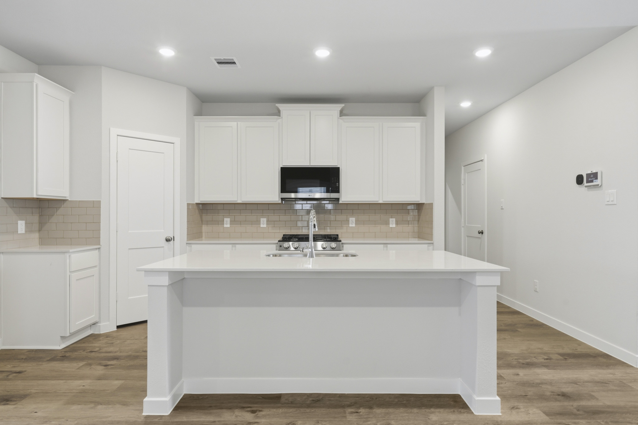 A kitchen with white cabinets.