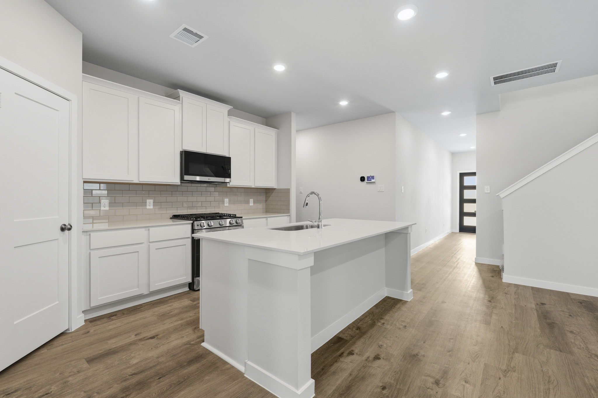 A kitchen with white cabinets.