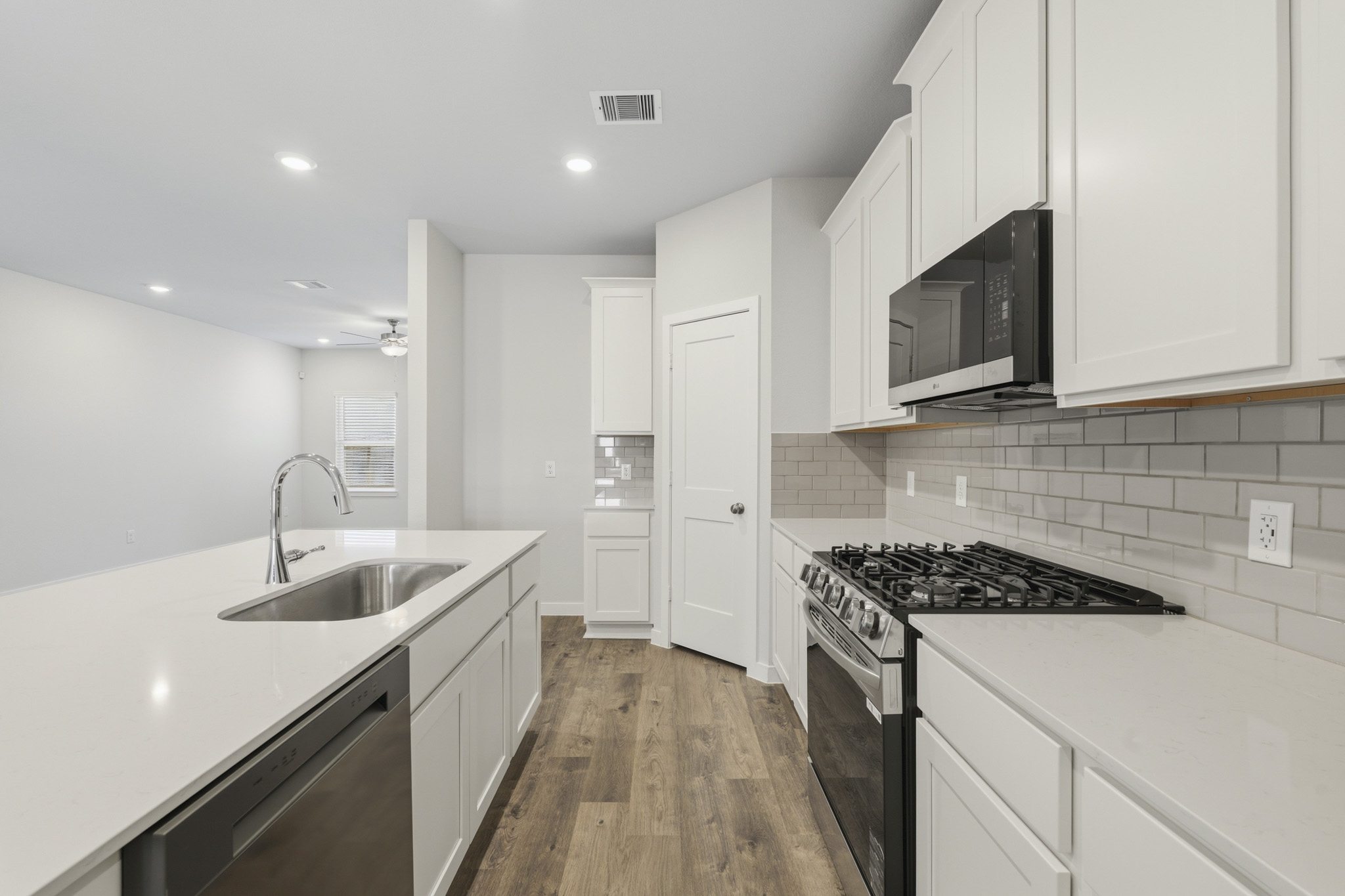 A kitchen with white cabinets.