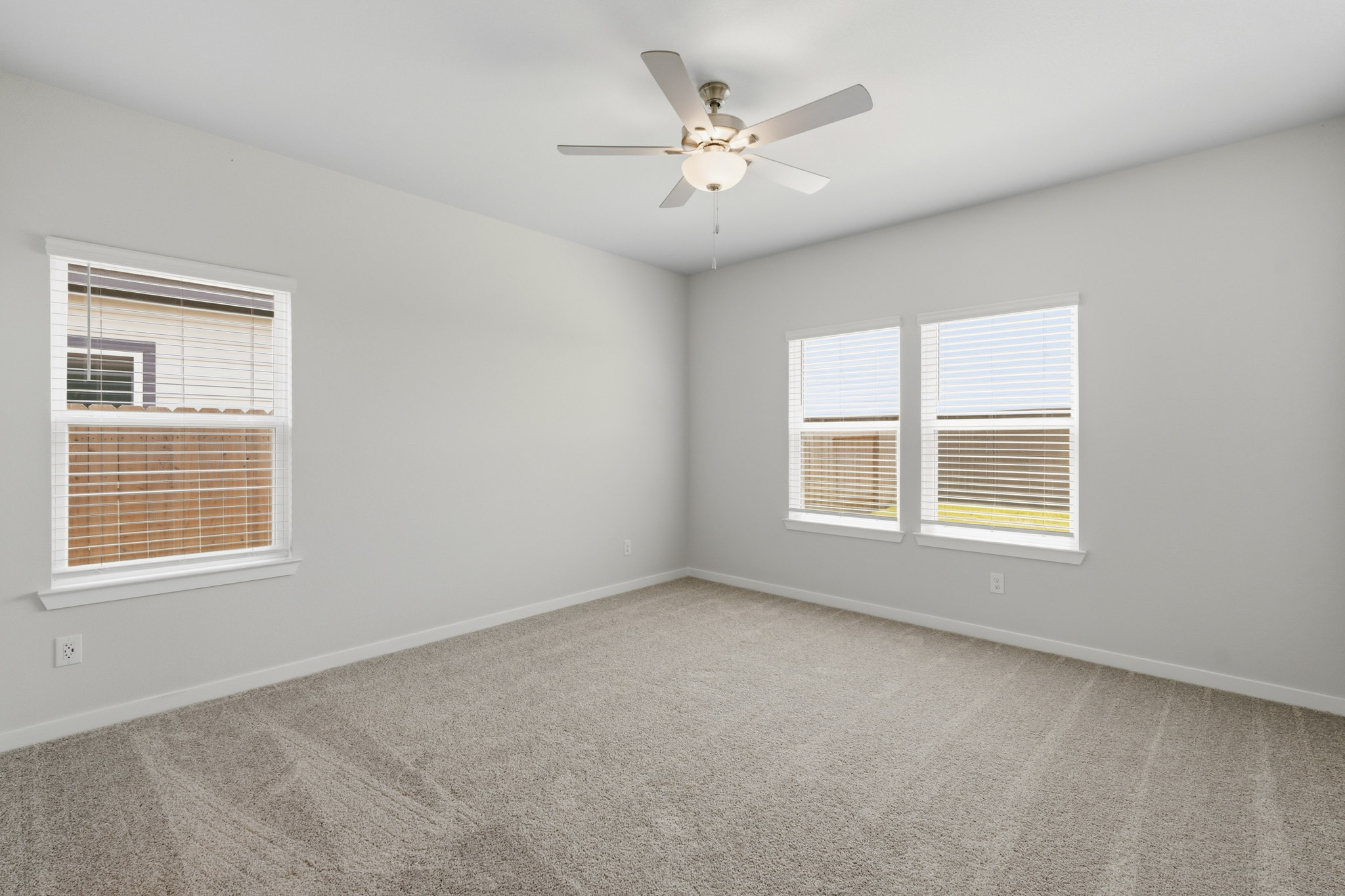 A room with a ceiling fan and a window.