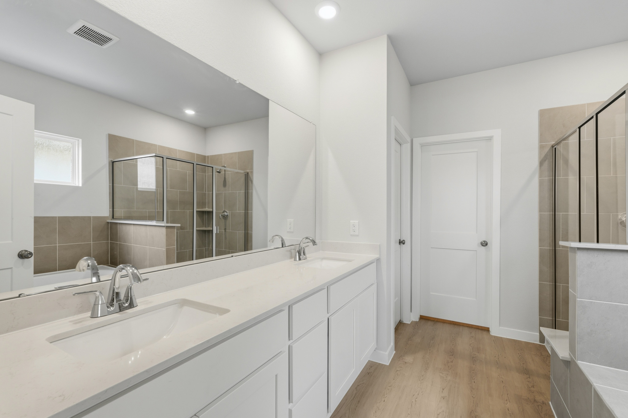 A bathroom with a large mirror.