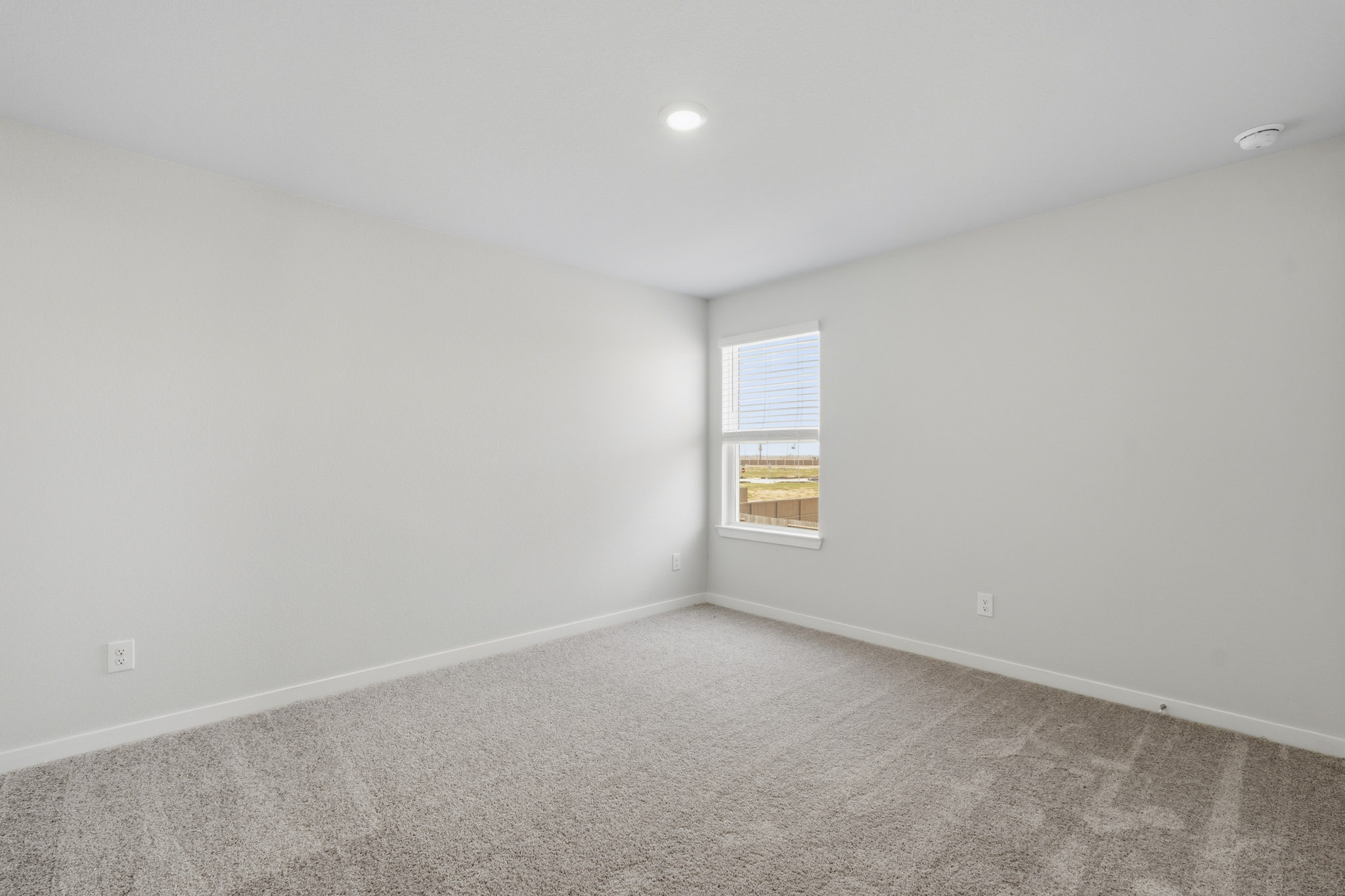 A room with a window and carpet.