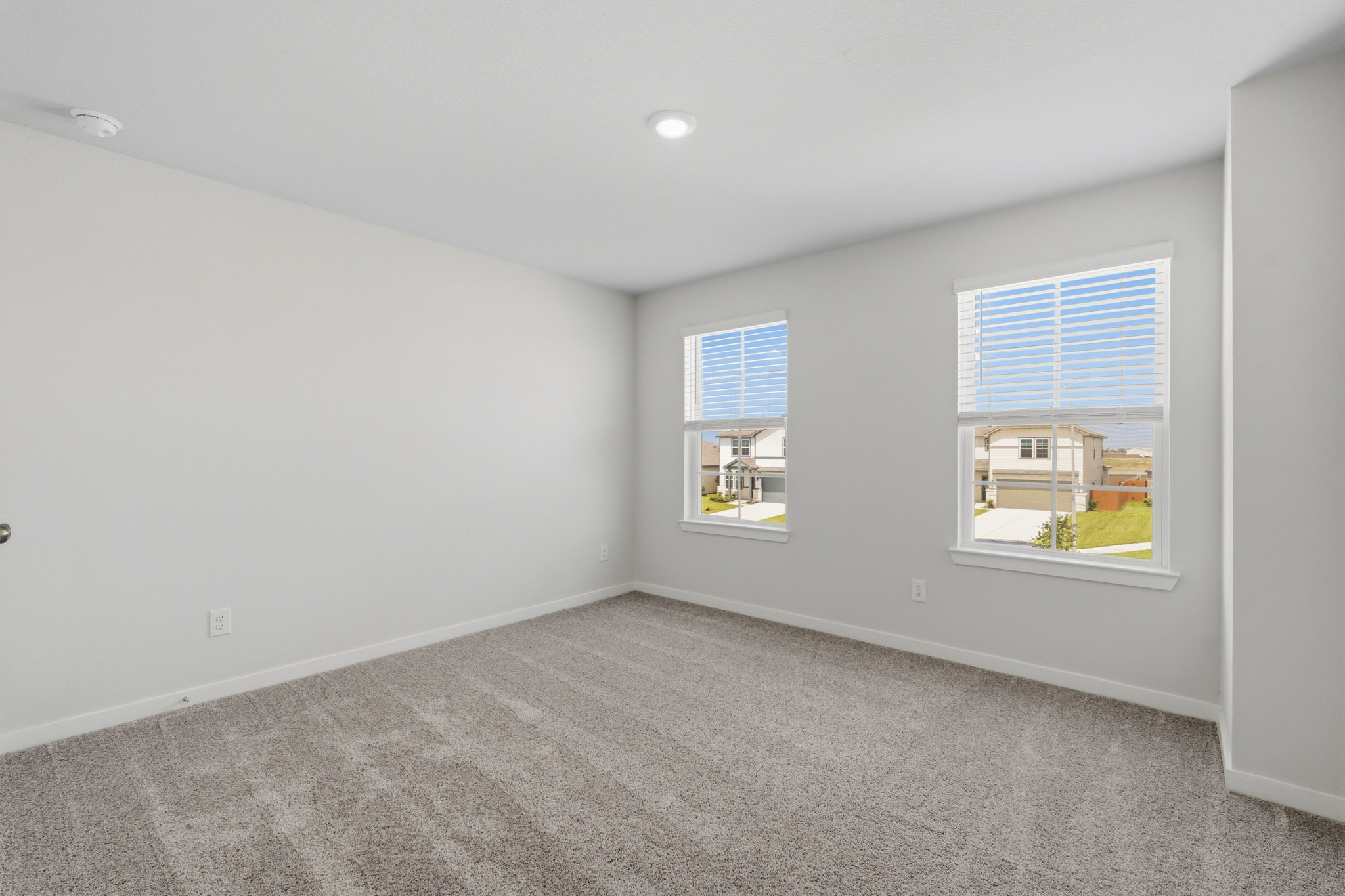 A room with windows and a carpet.