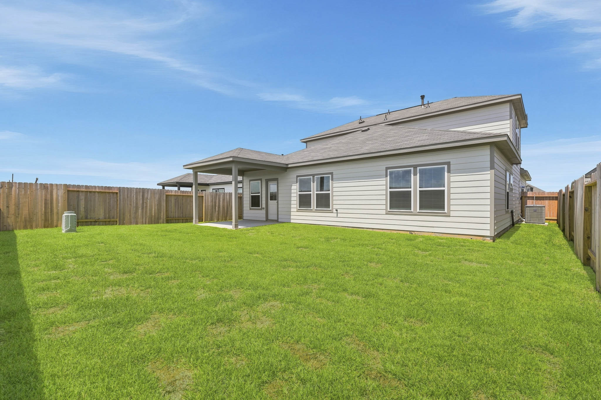 A house with a fence and grass with Auckland War Memorial Museum in the background.