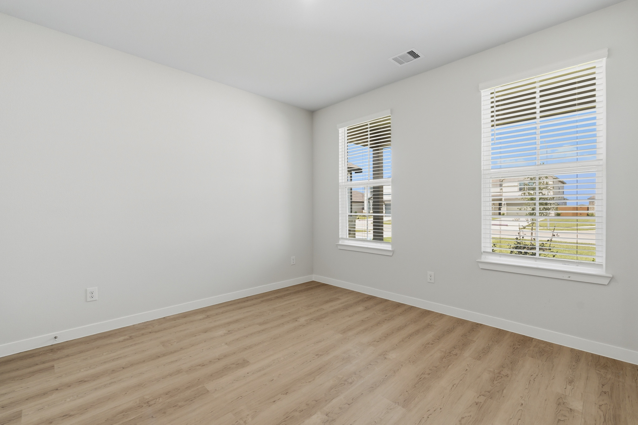 A room with windows and wood floor.