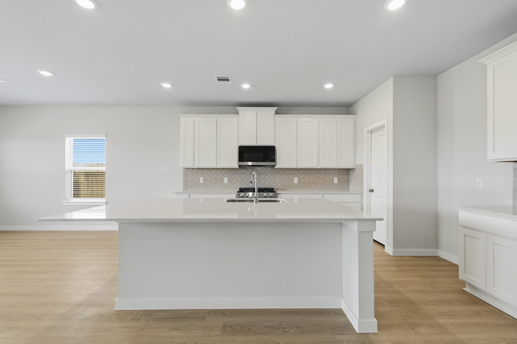 A kitchen with white cabinets.