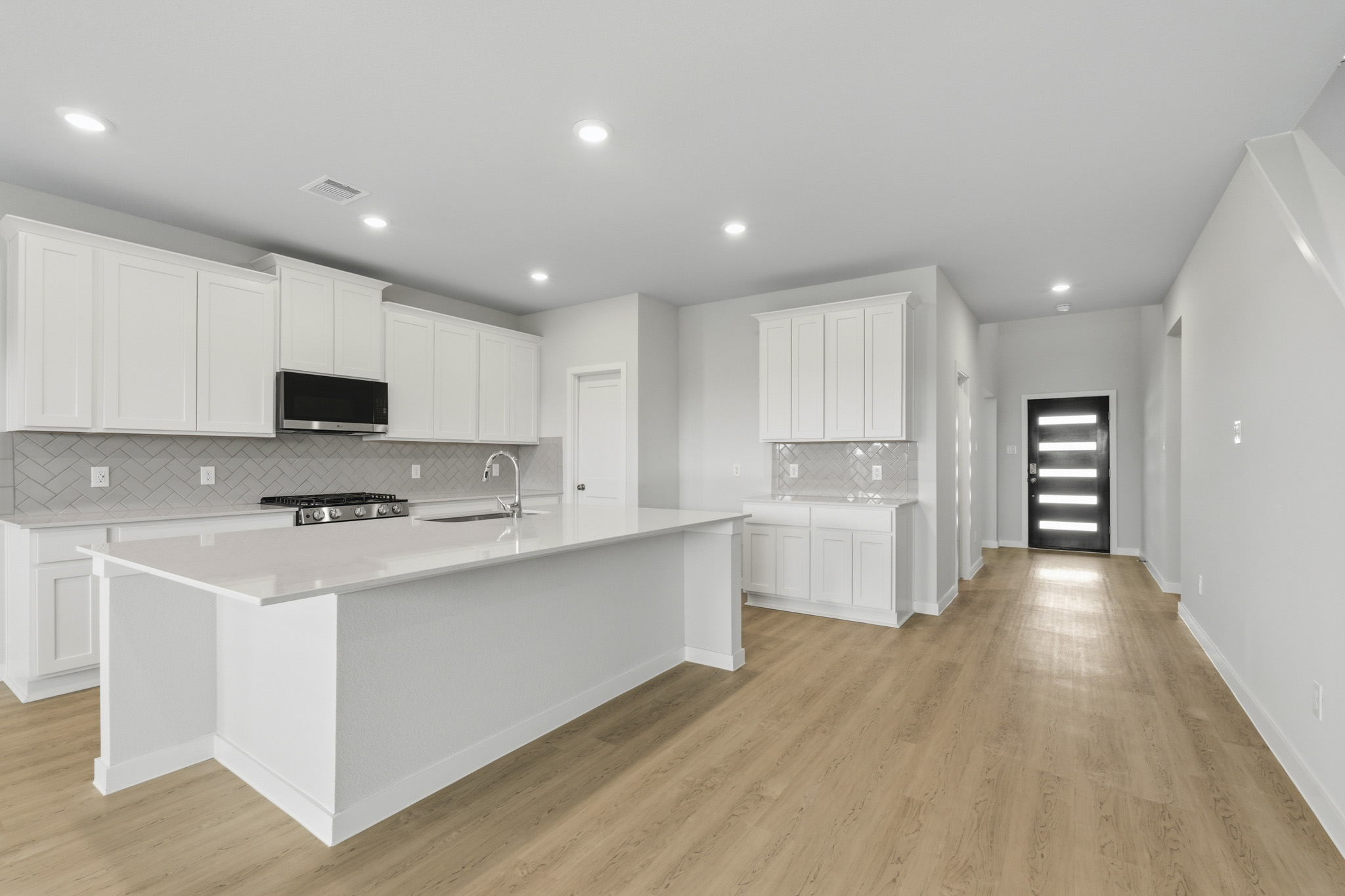 A kitchen with white cabinets.