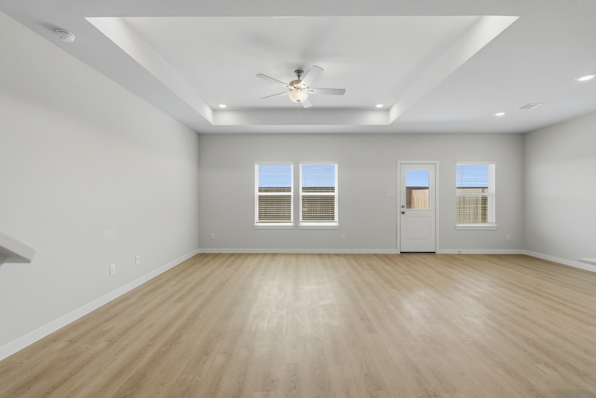 A room with a wood floor and a ceiling fan.