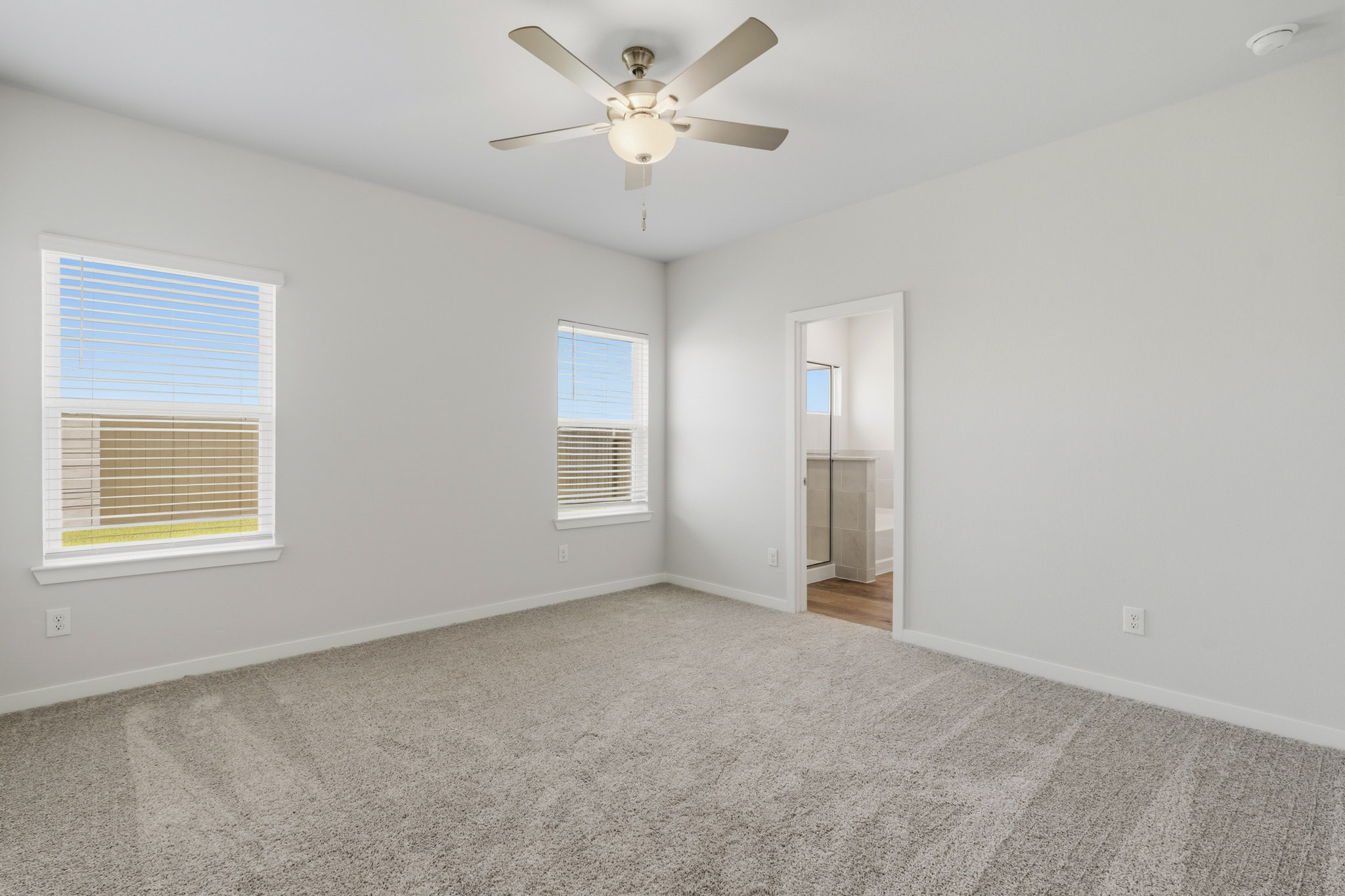 A room with a ceiling fan and a door.