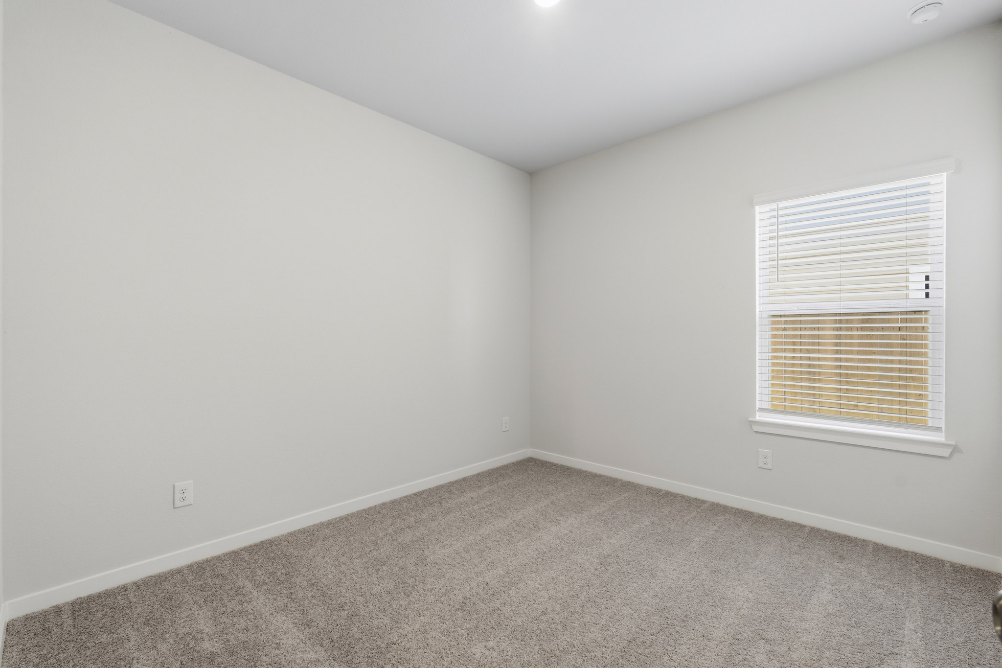 A room with a window and carpet.