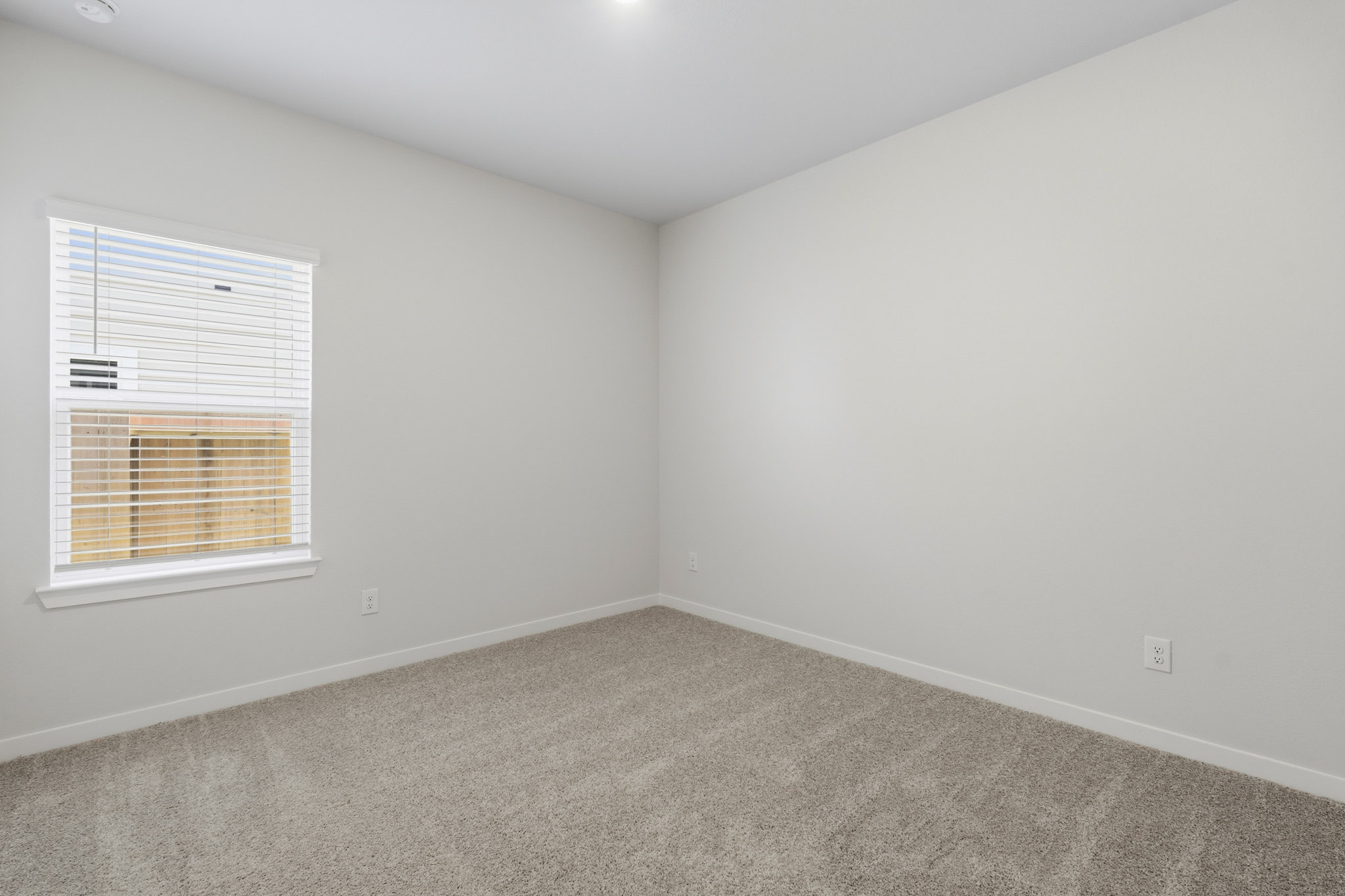 A room with a window and carpet.