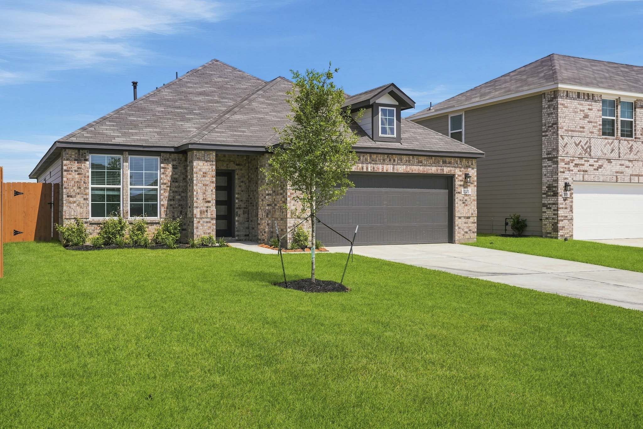 A house with a tree in the front yard.