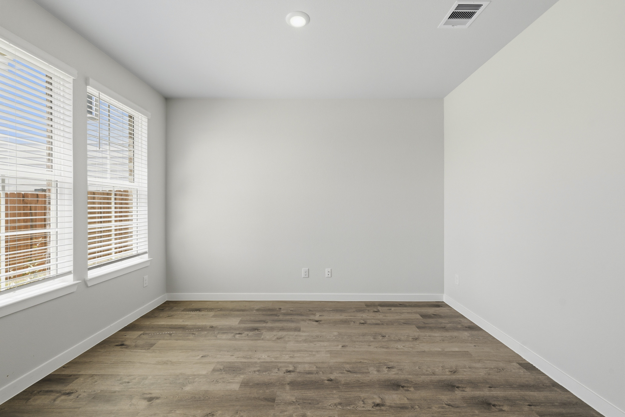 A room with a wood floor and windows.