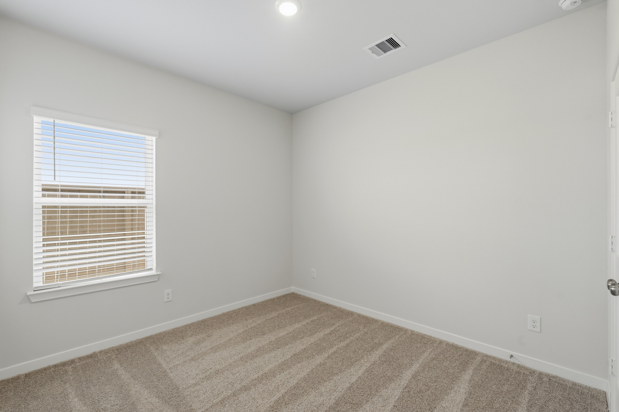 A room with a window and a rug.