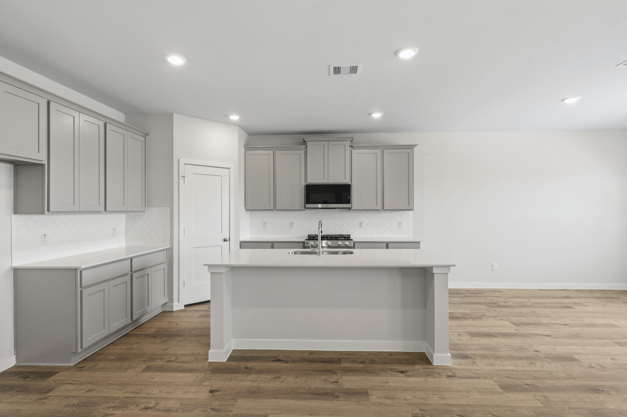 A kitchen with white cabinets.